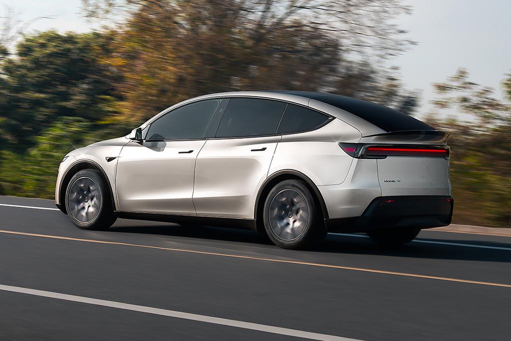 A sleek blue electric car is parked outdoors on a sunny day, with green grass and trees in the background and a partly cloudy sky overhead.