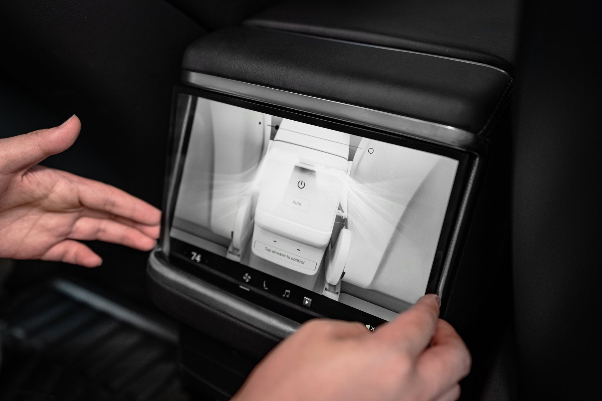 Skilled hands skillfully navigate a digital touchscreen embedded in a vehicle's backseat, enhanced with anti-fingerprint technology. The screen displays air conditioning controls with a power button and options for temperature and airflow, all safeguarded by the sleek JOWUA Tempered Glass Screen Protector (Model S/X).