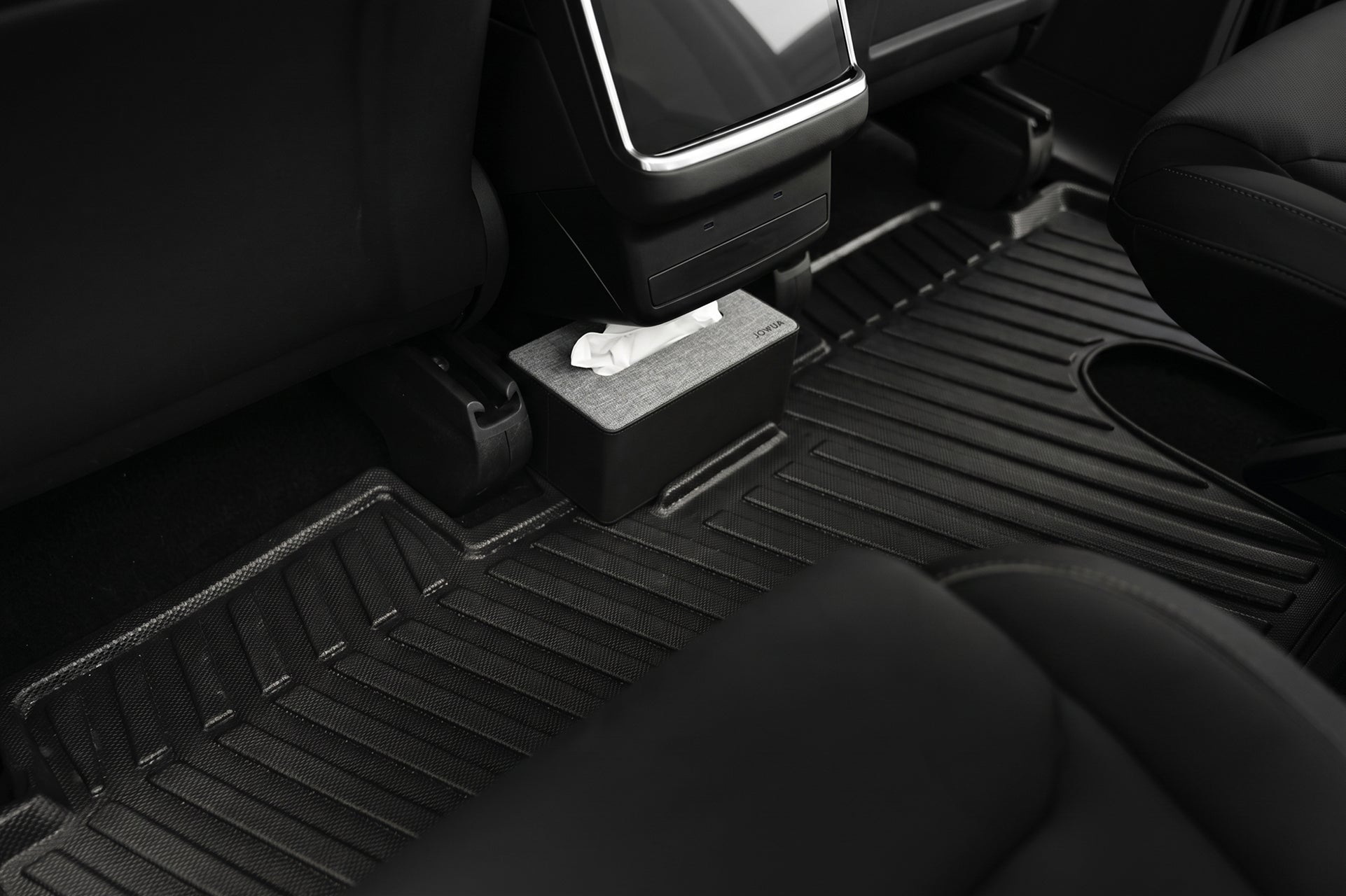 A close-up of the backseat floor shows JOWUA Model X All-Weather Floor Liners and a tissue box on a raised section near the rear center console, with two black car seats and part of the console also visible.