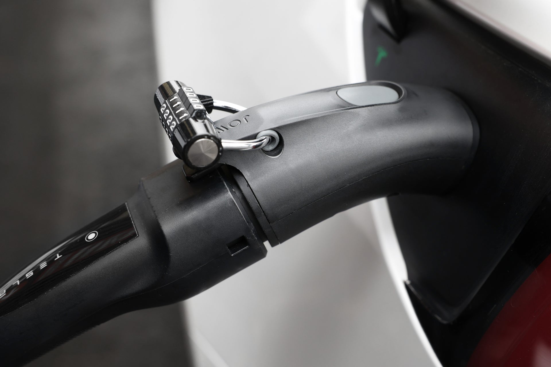 A close-up shows the JOWUA CCS2 to NACS DC/AC Charging Adapter Set, secured with a combination padlock, connecting a black charging plug to a white electric vehicle for Tesla CCS compatibility.
