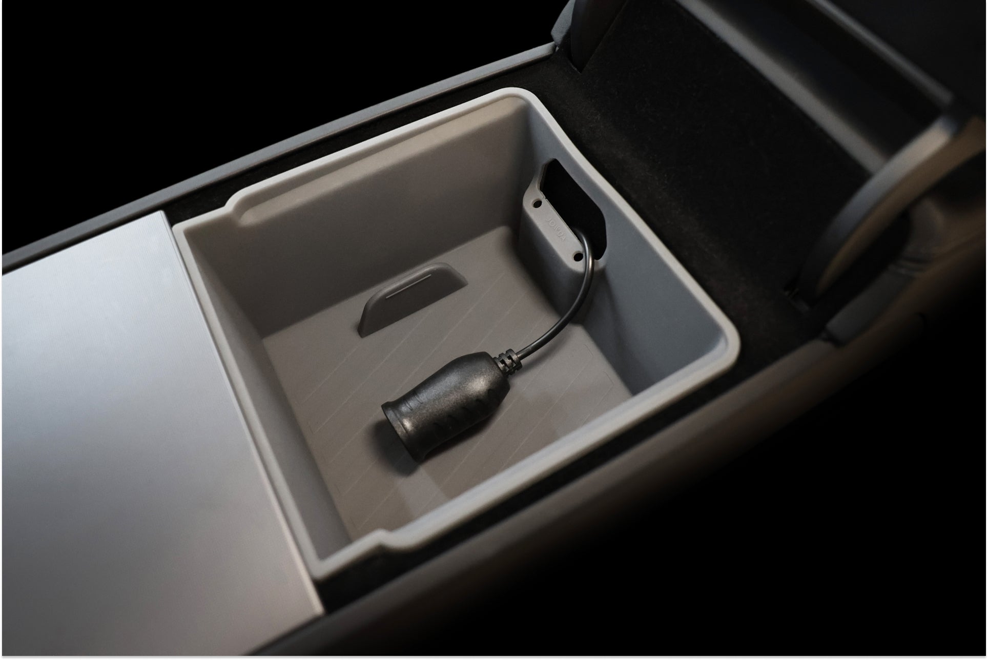 A close-up of the JOWUA Armrest Organizer Set for Tesla Model Y Juniper 2025+/Model 3 Highland 2024+ shows its empty tray with a metallic, bullet-shaped cable organizer—perfect for upgrading your center console storage.