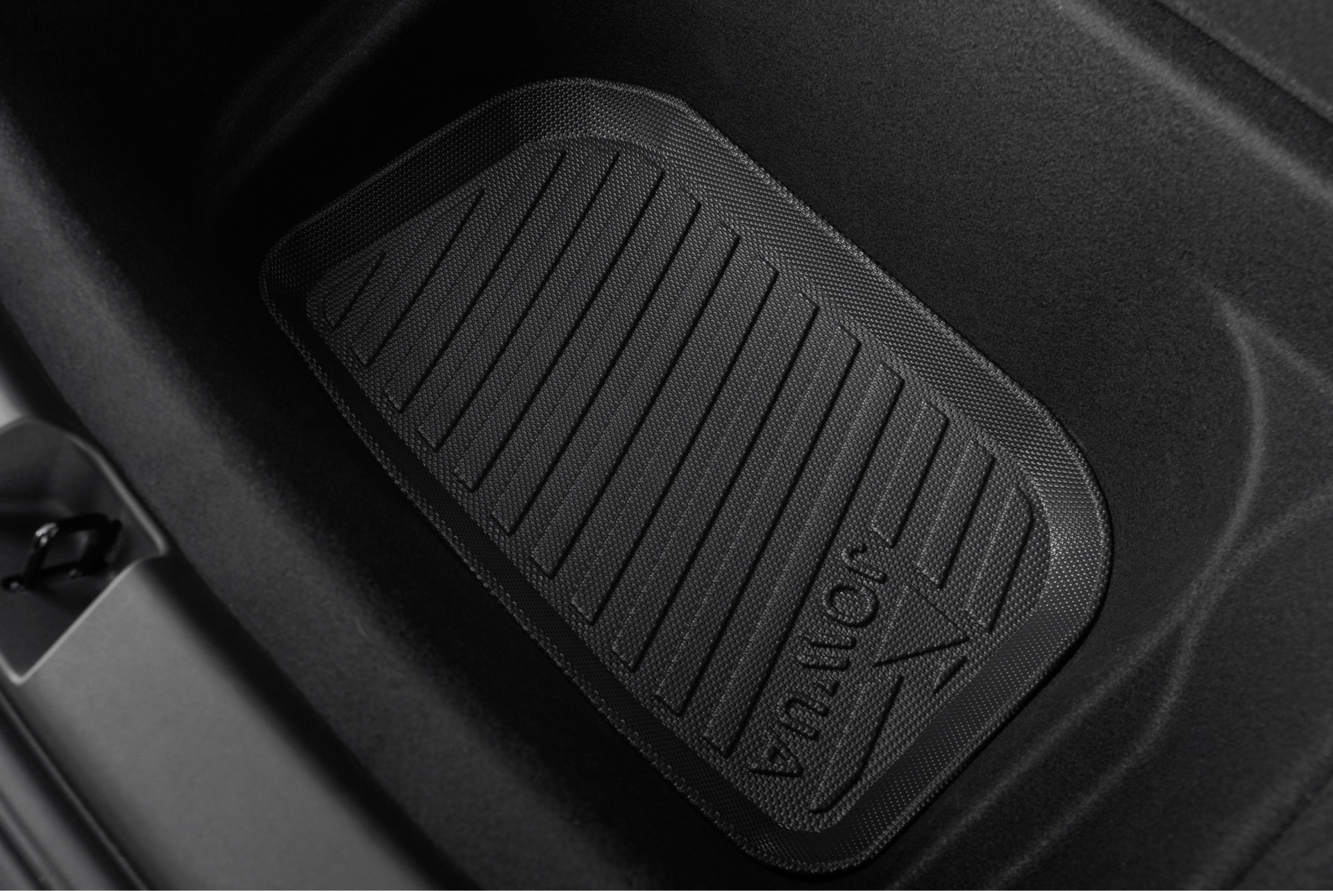 A close-up of the JOWUA Model Y Trunk Combo (2018-2024) with a textured black rubber finish and arrow design—an essential accessory for your Tesla Model Y.