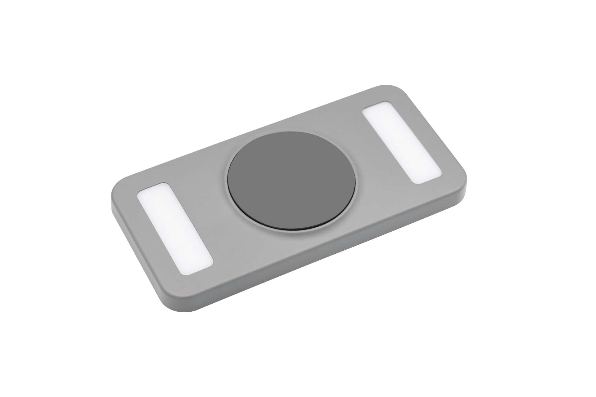 Introducing the JOWUA Portable LED Light Compatible with MagSafe Wireless Charging: a sleek, rectangular gray device featuring a large circular button at its center and two smaller rectangular white sections on either side, reminiscent of a contemporary remote control or electronic gadget. This product now boasts multi-stage lighting adjustment for creating your ideal ambiance.