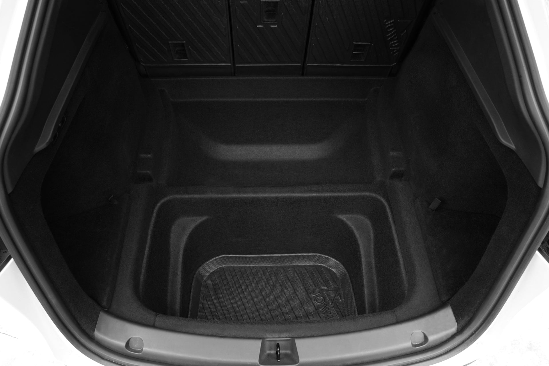 A close-up of the empty trunk in a Tesla Model Y (Juniper 2025+) with the JOWUA EasyShield Waterproof Trunk Liner + Rear Seats Back Cover Bundle, featuring durable molded TPE, dark panels, and divided storage sections.