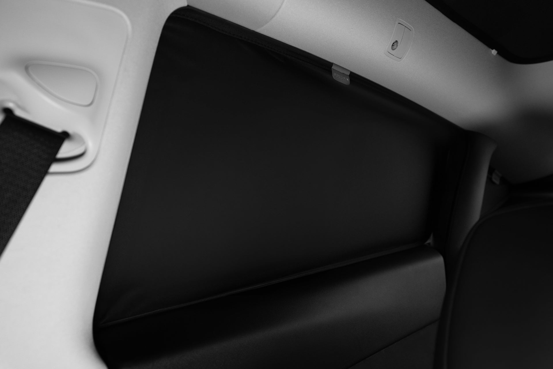 Close-up of a Model Y interior (2021-2024) with a JOWUA Side + Rear Liftgate Window Sunshade, featuring high-density fabric for added privacy and security. Seatbelt, seat part, and trim details are also visible.