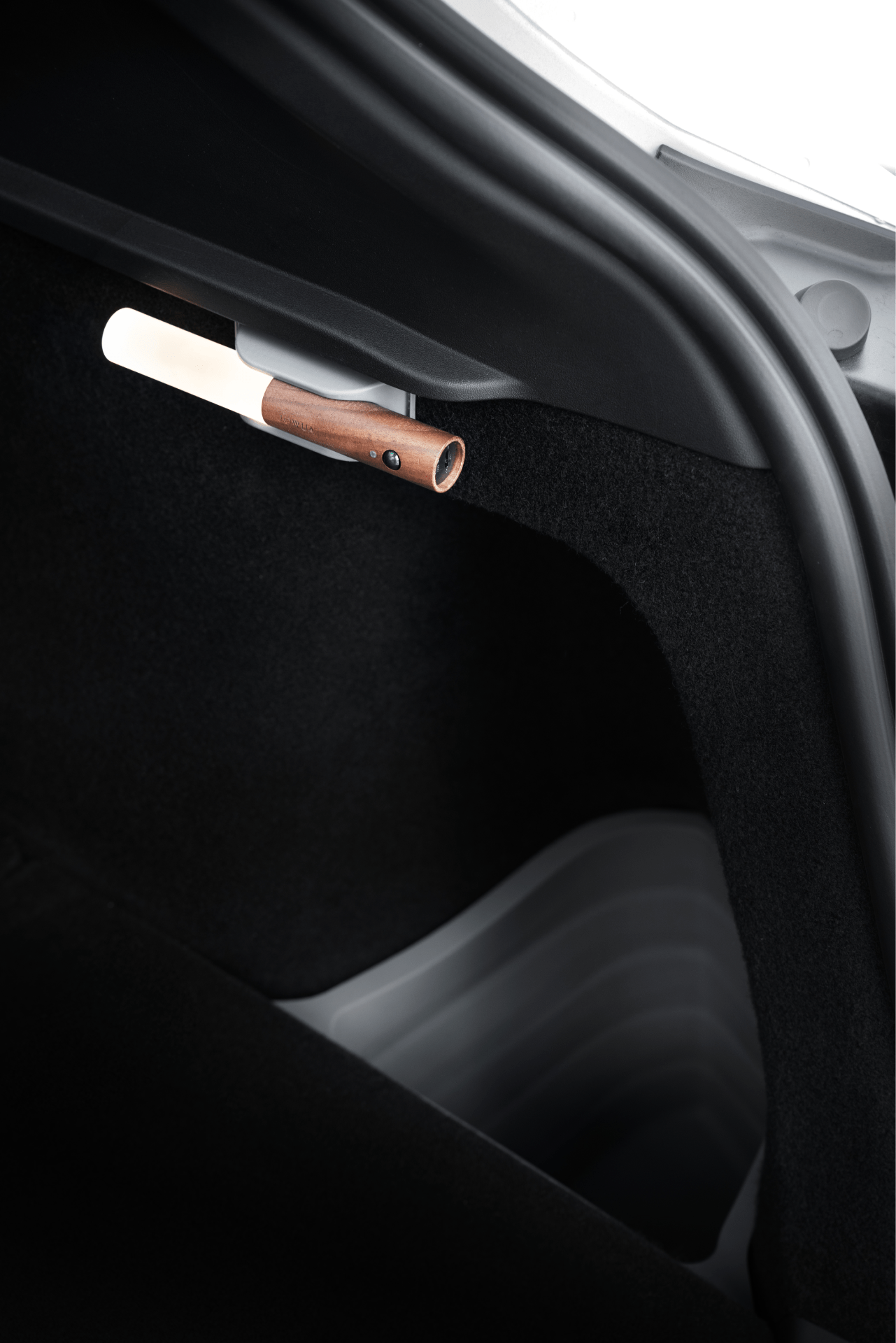 A close-up of a Model Y trunk shows a wooden-handled umbrella neatly stored in the JOWUA Trunk Storage Bins Bundle (2018-2024), attached to the side panel.