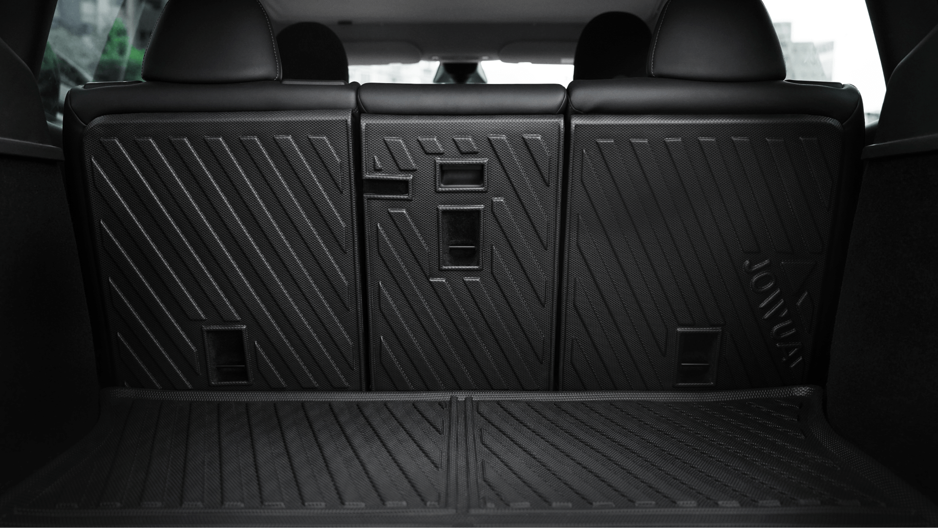 Close-up of Model Y Trunk Combo (2018-2024) by JOWUA: black, textured rubber trunk liners with geometric patterns protect the cargo area floor and rear seatbacks. Seats are upright, showcasing full coverage.
