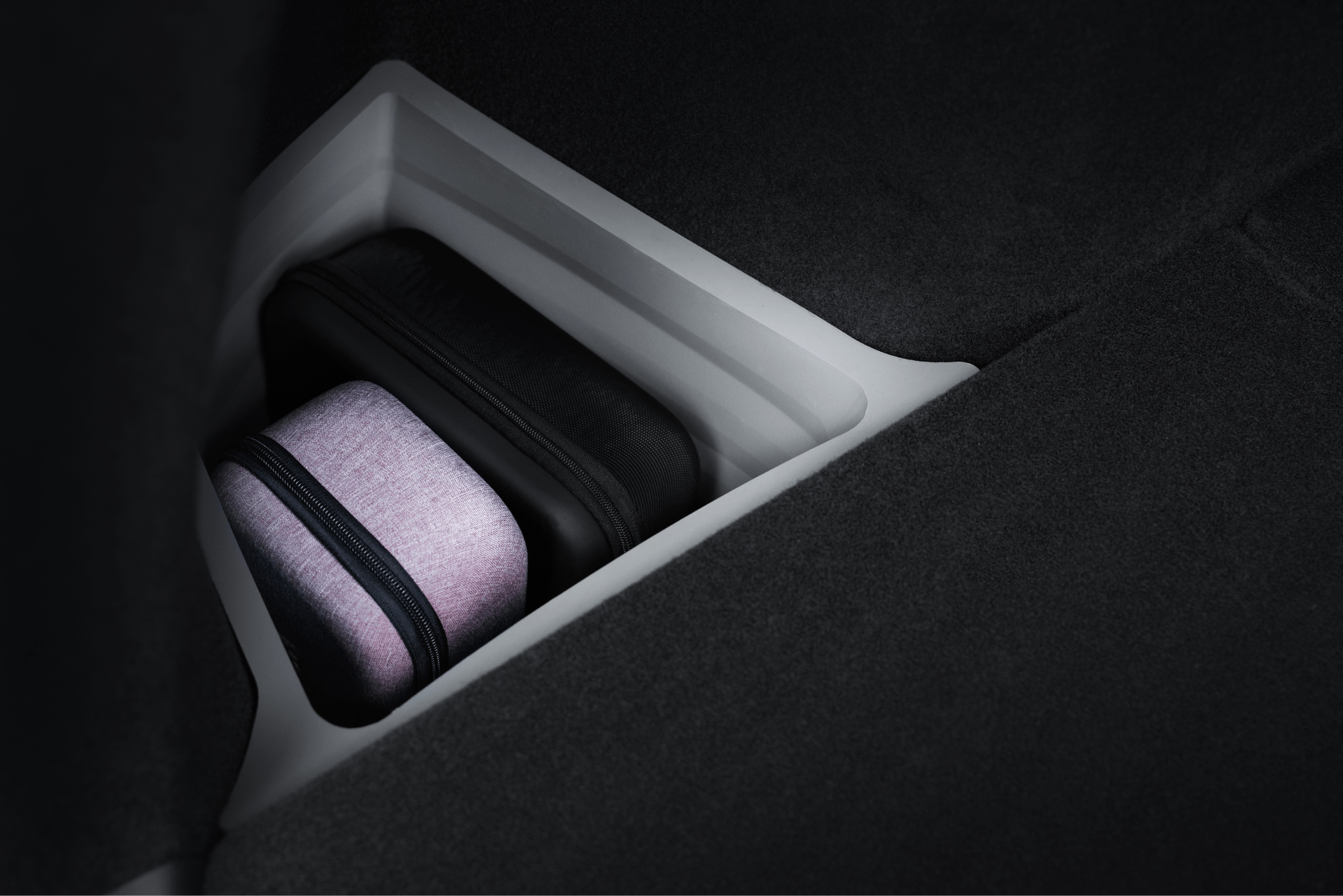 The JOWUA Model Y Juniper Trunk Combo (2025+) features two zippered cases—black and light purple—organized in a recessed, dark-lined compartment. Thoughtful lighting enhances Tesla Model Y storage and easy trunk access.