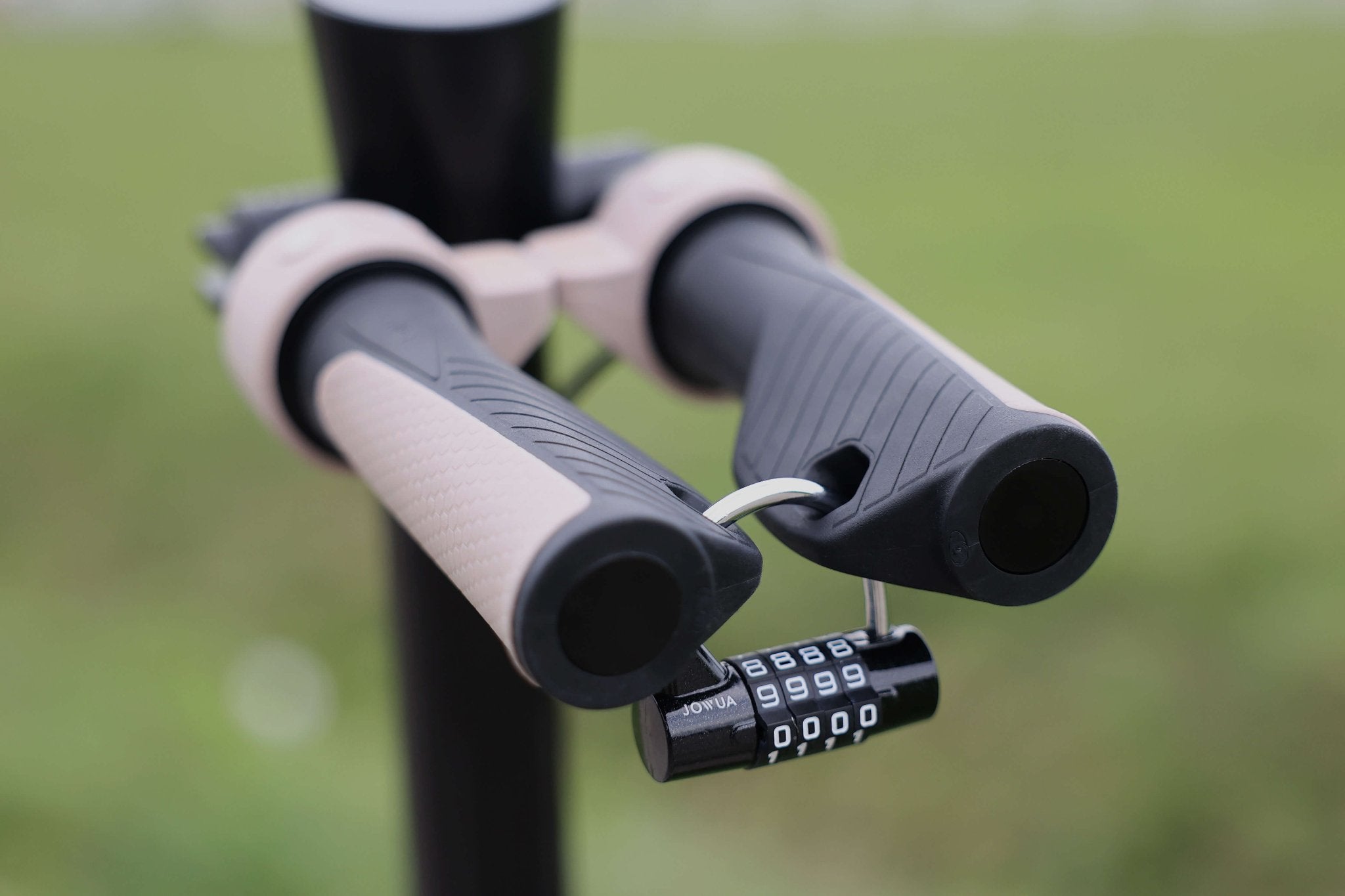 Close-up of two black and beige handles from the JOWUA Folding Electric Scooter (Long Range) for Tesla (S3XY), secured with an anti-theft padlock set to