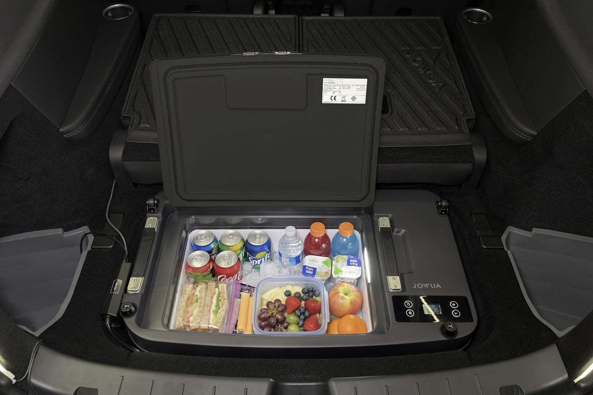 A JOWUA Car Refrigerator for Tesla Model Y L (2026+) with intelligent dual-mode cooling installed in a vehicle trunk, filled with assorted canned drinks, water bottles, fruit, and snacks.