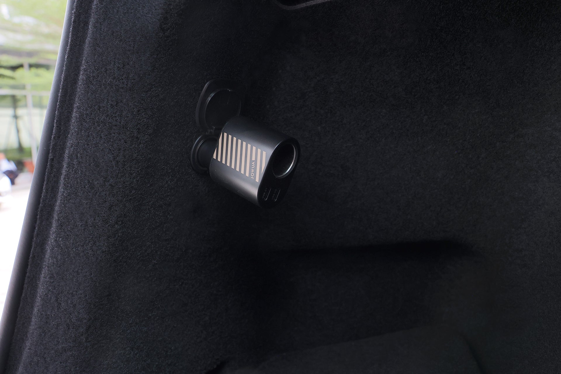 A compact black dashcam is mounted near a vehicle window, powered by the JOWUA 3 in 1 Type-C Car Charger, allowing easy car power expansion.