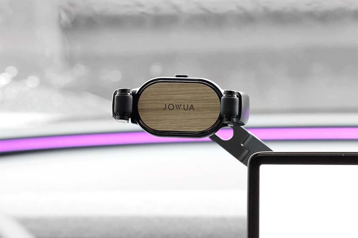 A close-up of JOWUA's 6D Invisible Foldaway Car Mount (Universal) shows its innovative wooden finish with black sides. A black rectangular device screen appears from the bottom right, set against a blurred interior with purple accent lighting, highlighting this durable design marvel.