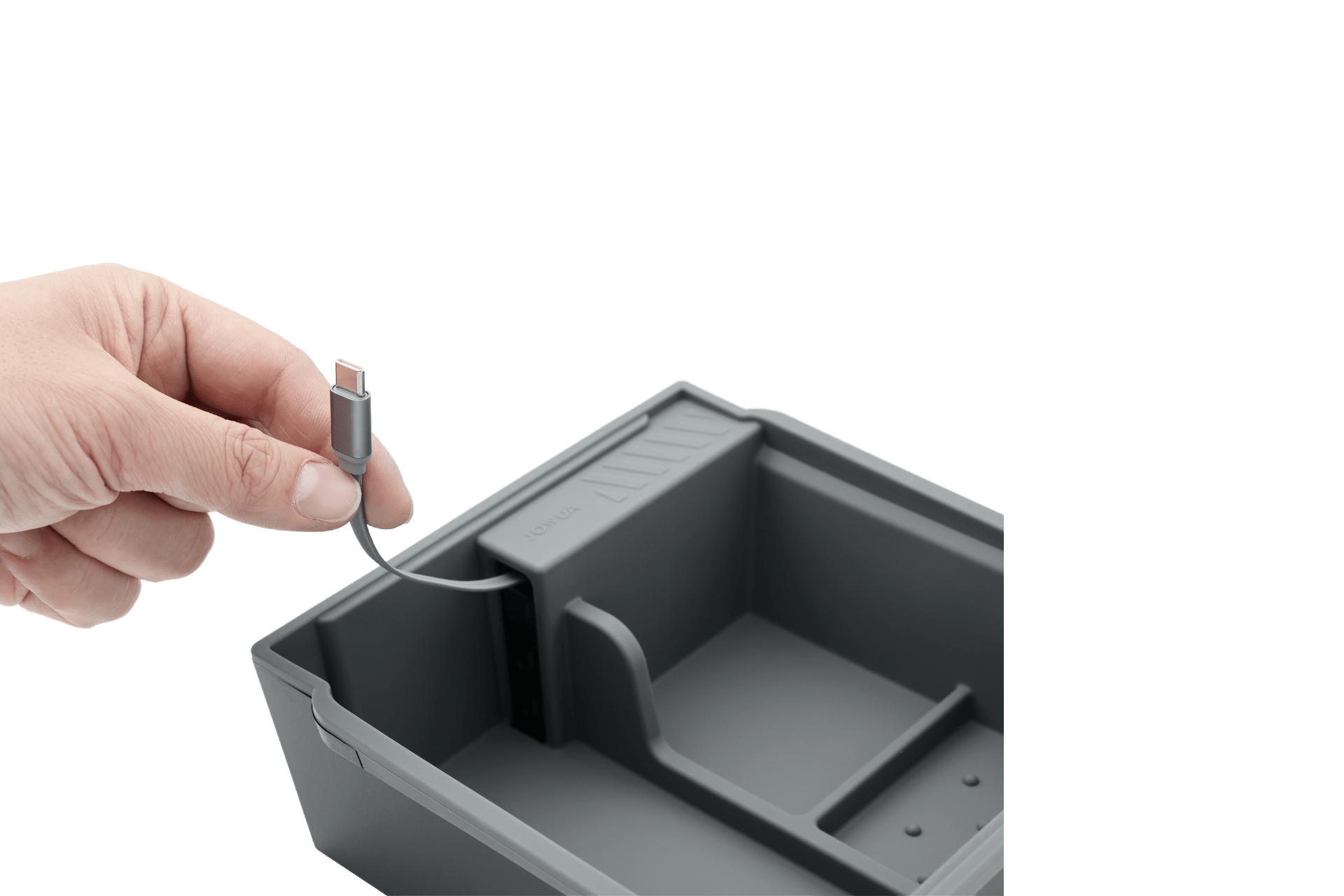 A hand holds a USB-C cable above the JOWUA Armrest Storage Organizer Set with Power HUB for Tesla Model Y Standard 2026+, shown in gray with compartments, including a slot for the cable, against a white background.