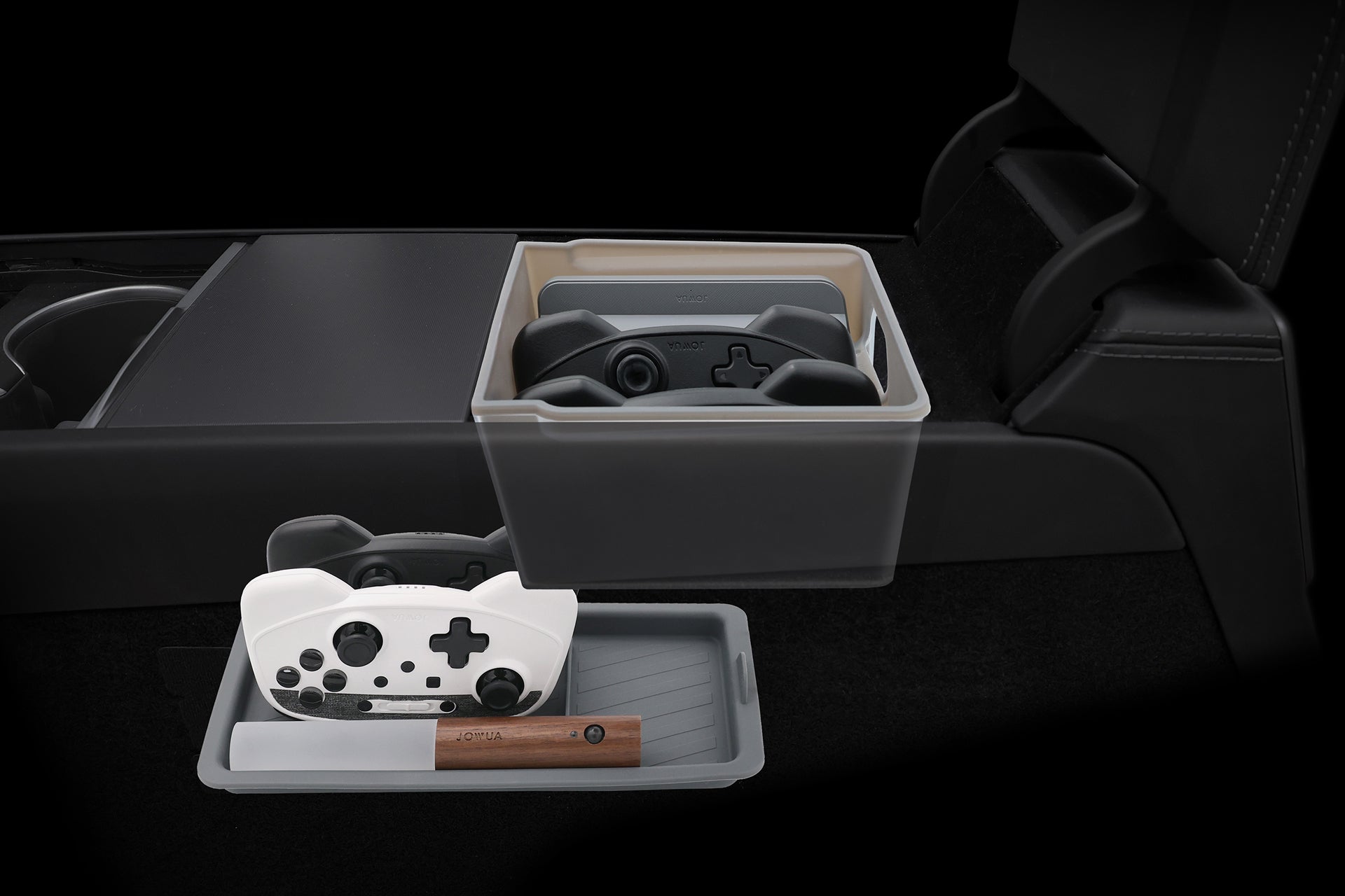 The JOWUA LED Center Console Combo for Tesla Model Y Juniper (2025+) stores two gaming controllers in the organizer, while a lower drawer holds a white controller and a brown pen or stylus. The background appears dark and minimal.