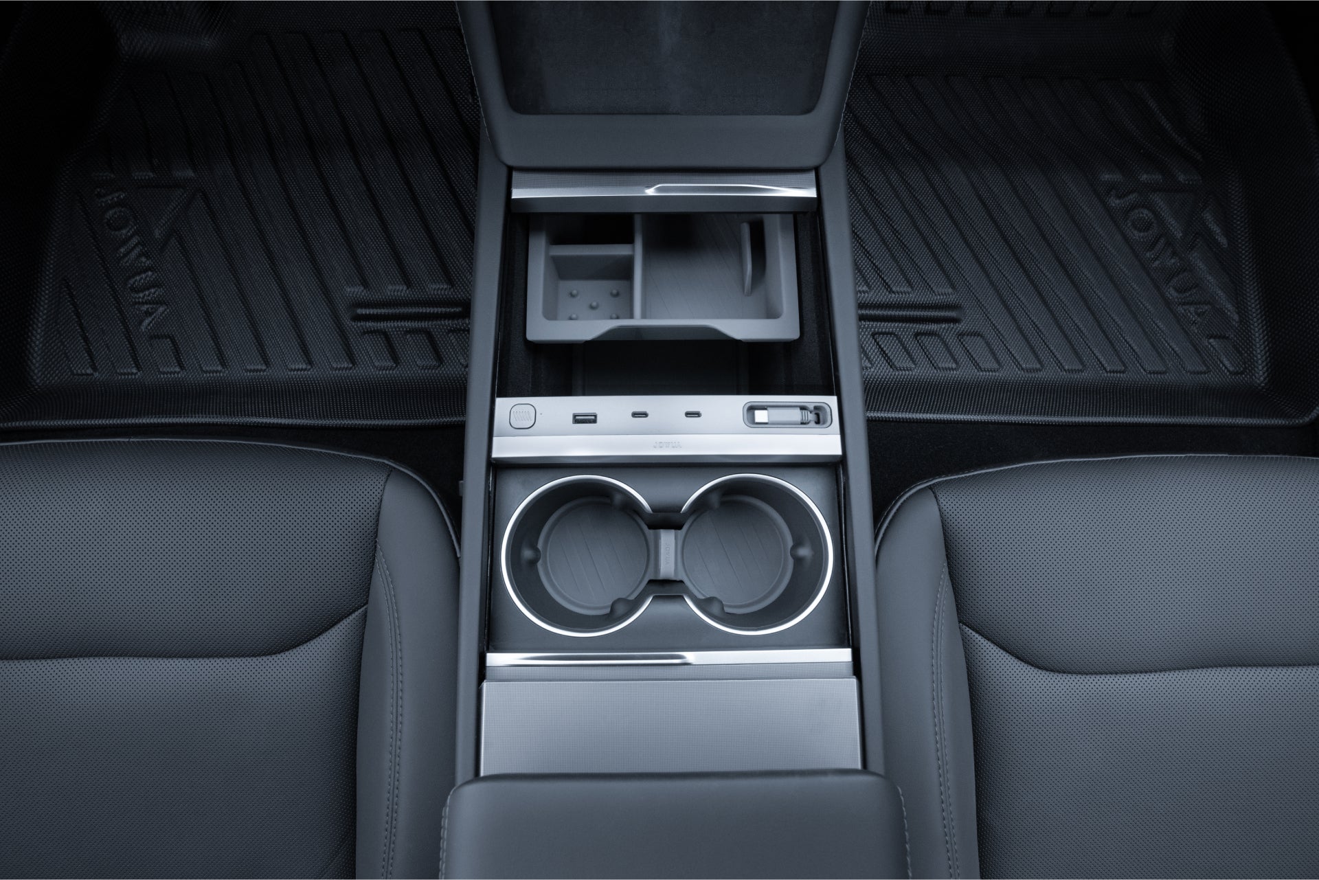 The LED Center Console Combo by JOWUA for the Tesla Reengineered Model 3 Highland (2024+) features a sleek design with two cup holders, a small storage compartment, and various control buttons. The seats and floor mats are designed to complement the modern aesthetic, while premium silicone accents provide enhanced durability and style.