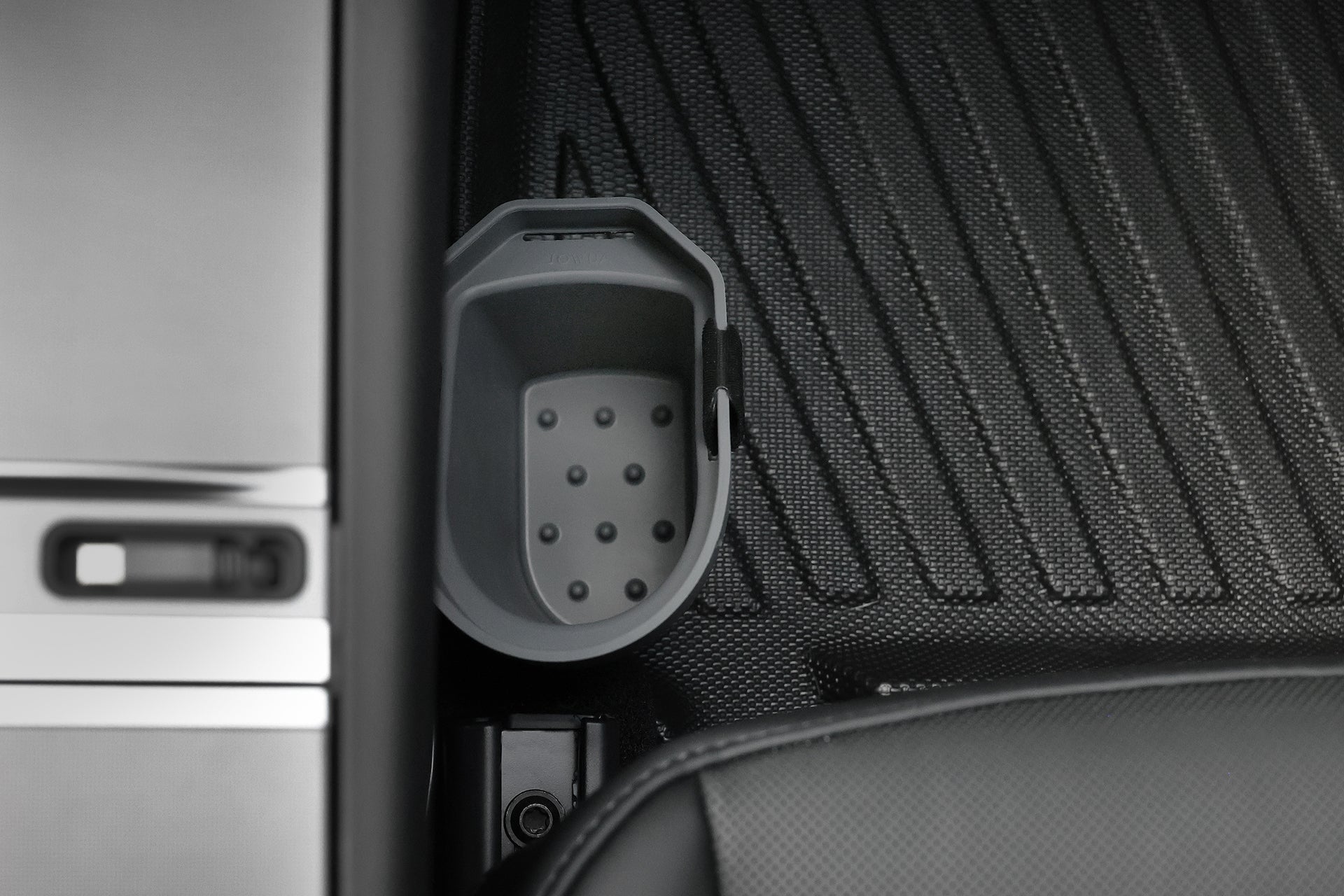 A close-up shows the JOWUA Door Side Storage Box (Set of 2) installed next to the center console on a textured black floor mat, with part of a car seat visible.