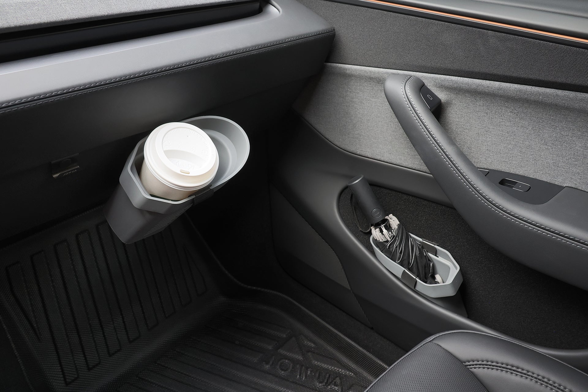 Car interior with a cup holder (coffee cup) and umbrella holder by the passenger seat; modern grey/black design features JOWUA Door Side Storage Box (Set of 2) silicone organizers in the door storage compartment.