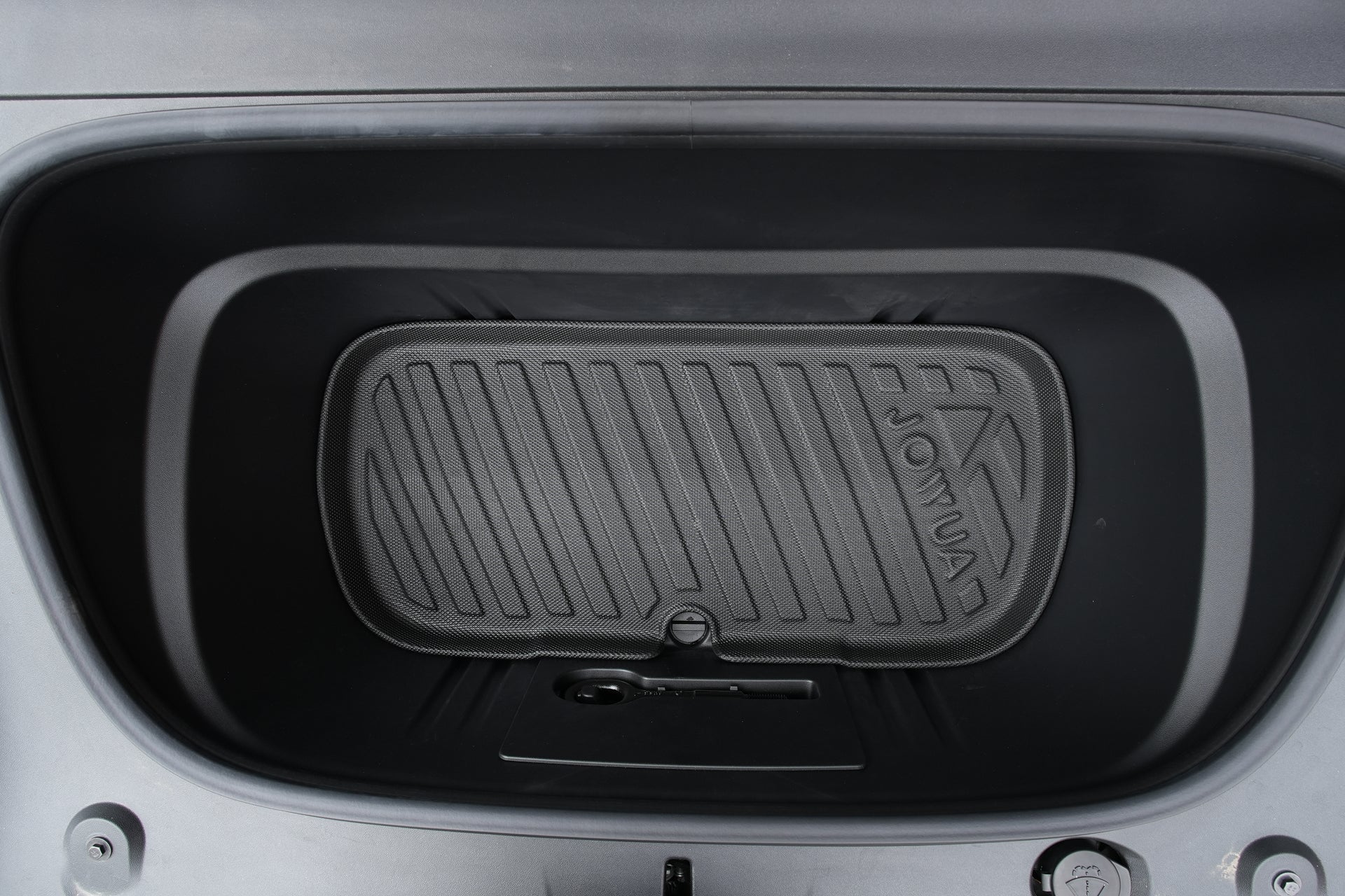 A close-up of an empty car frunk fitted with the JOWUA Model Y L (2026+) Interior / Trunk Full Coverage Liner Combo, showing the waterproof liner and small under-compartment, all surrounded by dark plastic trim.