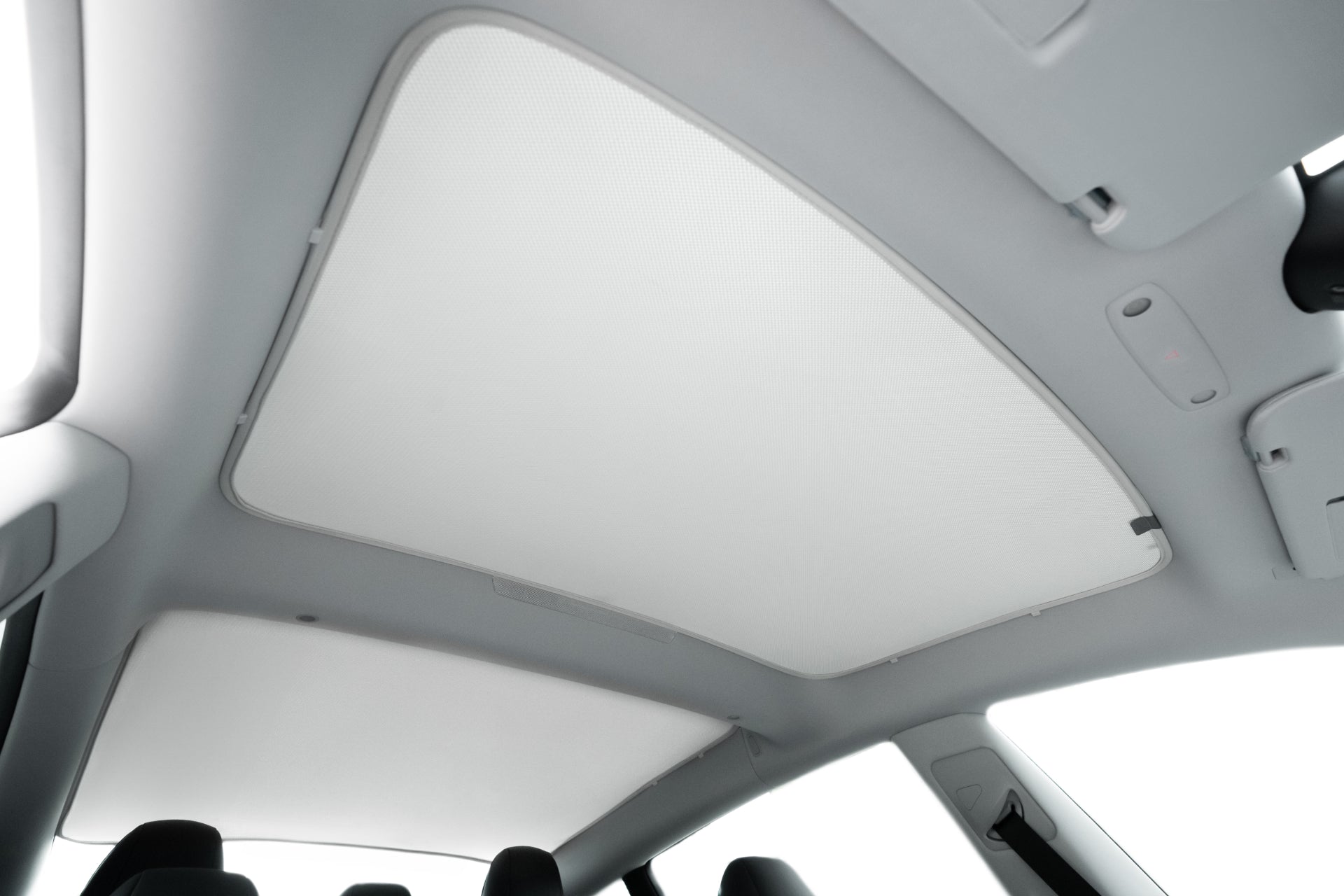 Interior view of a car with the JOWUA Model 3 (2024+ Highland) Glass Roof Sunshade (US Version) installed, covering the panoramic sunroof for UV blocking and heat reduction. Sunroof frame edges, roof, and seats are also visible.