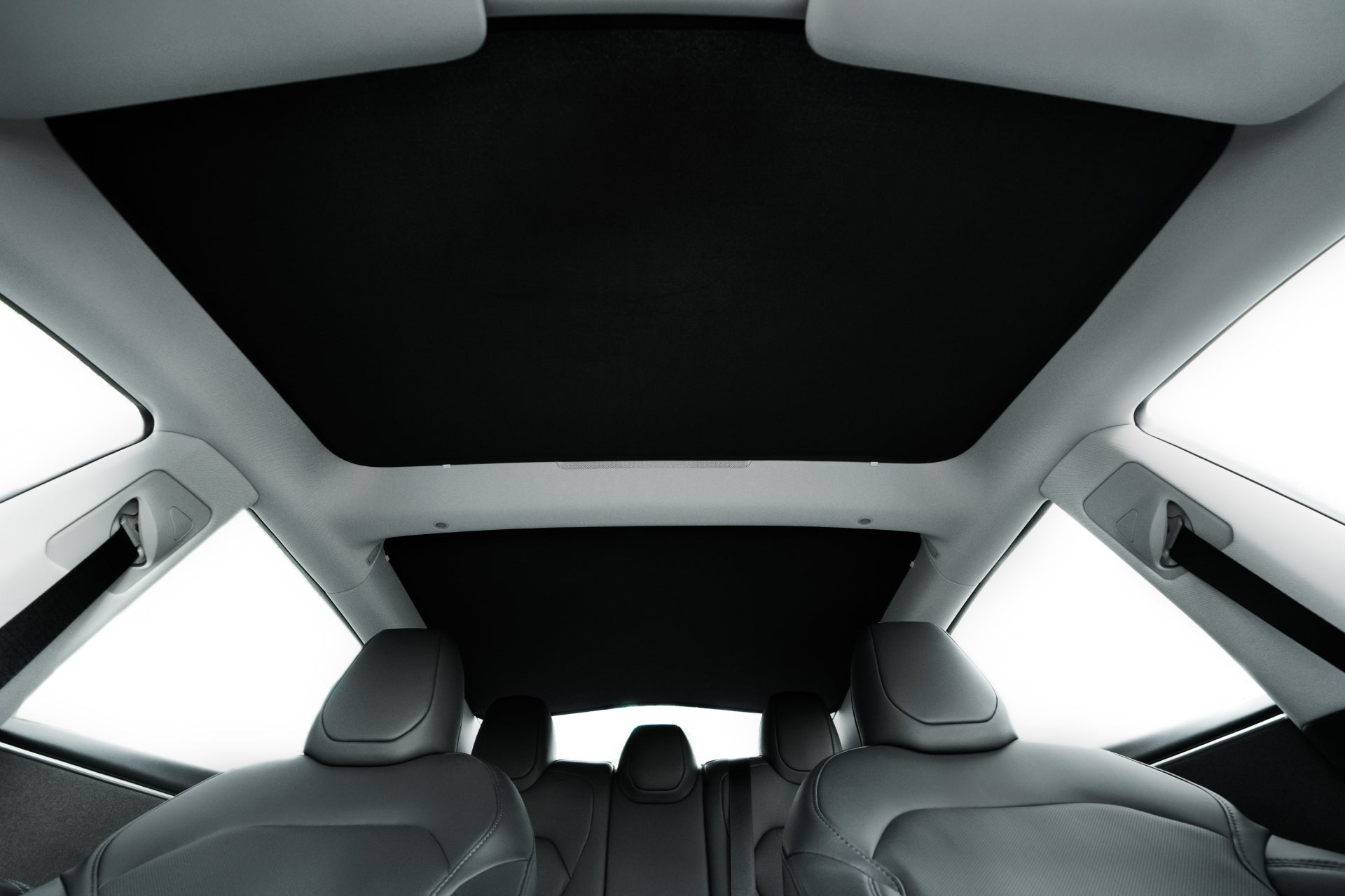 View from the back seat of a 2024+ Model 3 showing the JOWUA Glass Roof Sunshade (US Version) installed, with black and gray interior under bright light; designed to block UV and reduce heat.