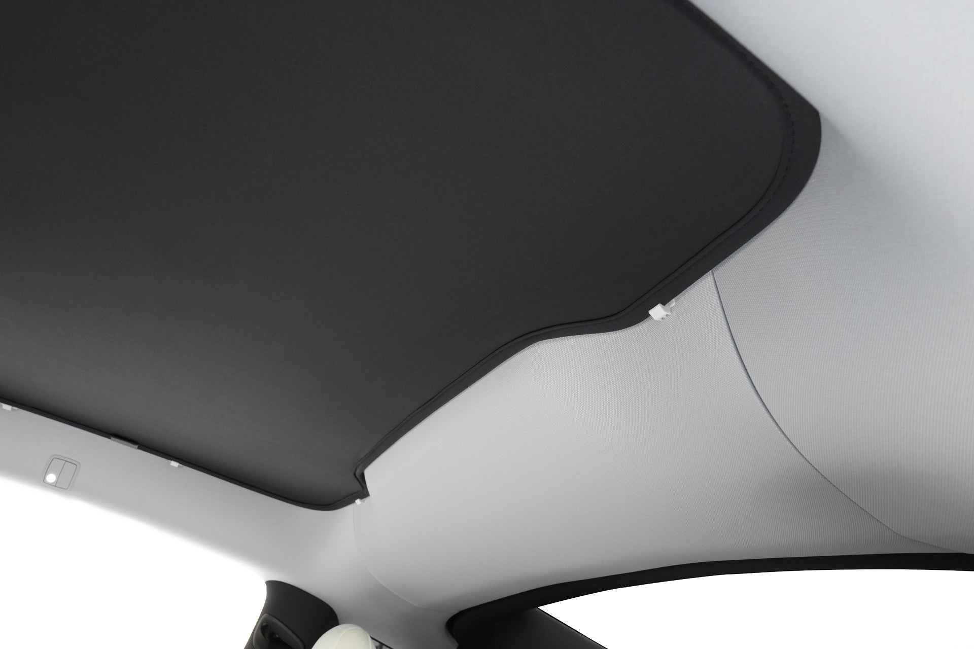 Close-up of the JOWUA Ultimate Sunshade Bundle Model Y Juniper (2025+) installed on a glass roof, providing UV protection. A blackout sunshade and light gray headliner are visible, with part of a seat shown at the bottom.