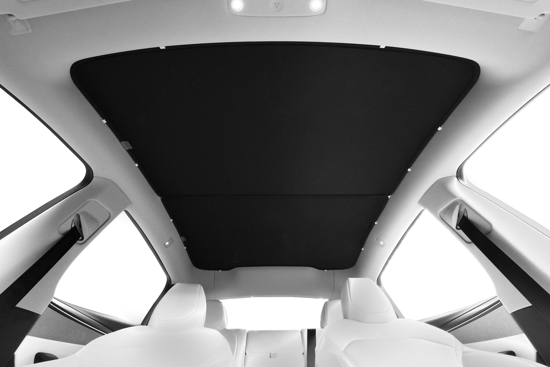 View from the back seat of a car with white seats and a large panoramic glass roof fitted with the JOWUA Ultimate Sunshade Bundle Model Y Juniper (2025+), letting in bright light while enhancing the modern look and providing UV protection.