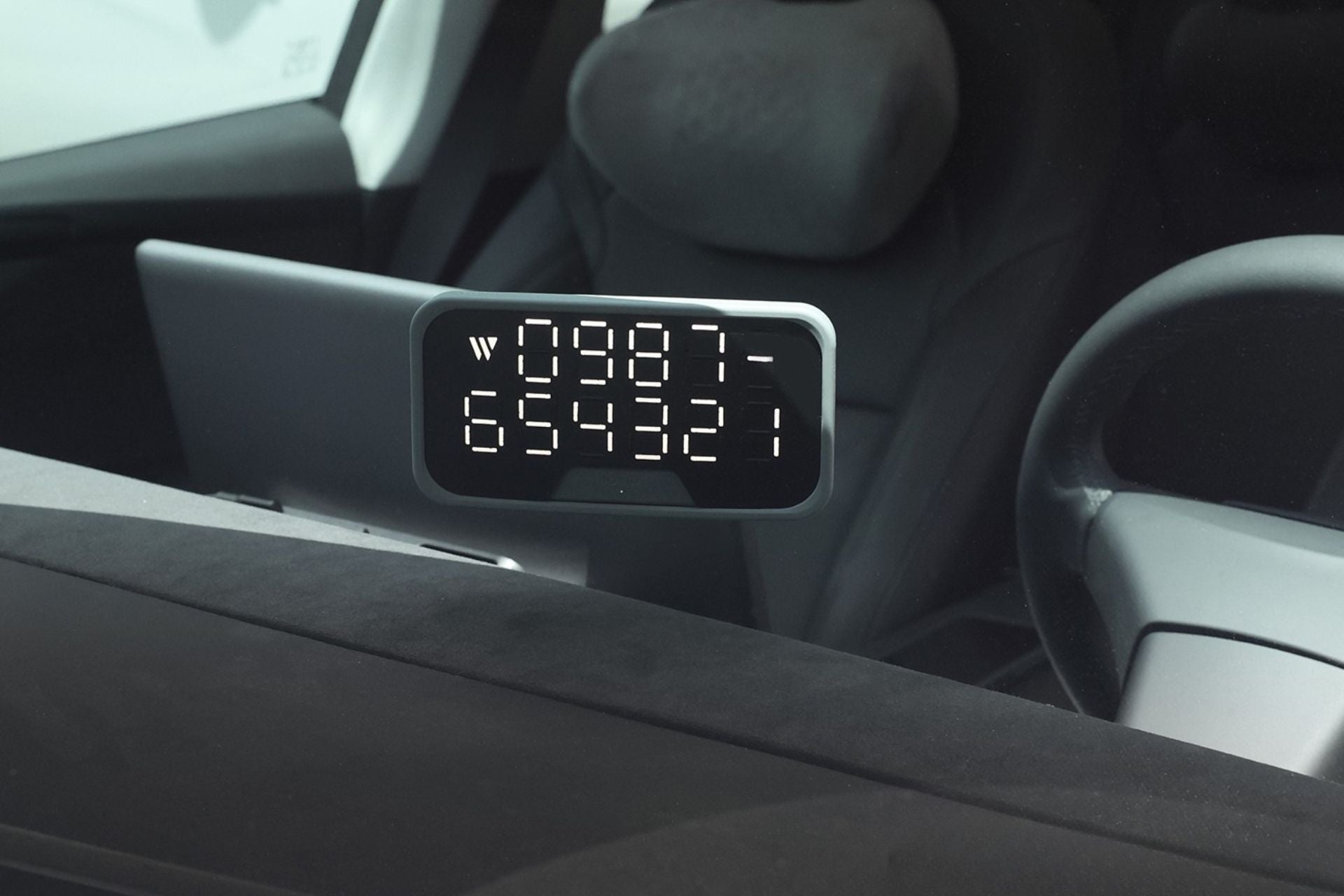 A close-up of a digital taxi meter inside a car displays the numbers 0987 over 654321. The dashboard, steering wheel, and seat are also partially visible, alongside a JOWUA MagSafe LED Light with Light Stencil Set integrated neatly into the console.
