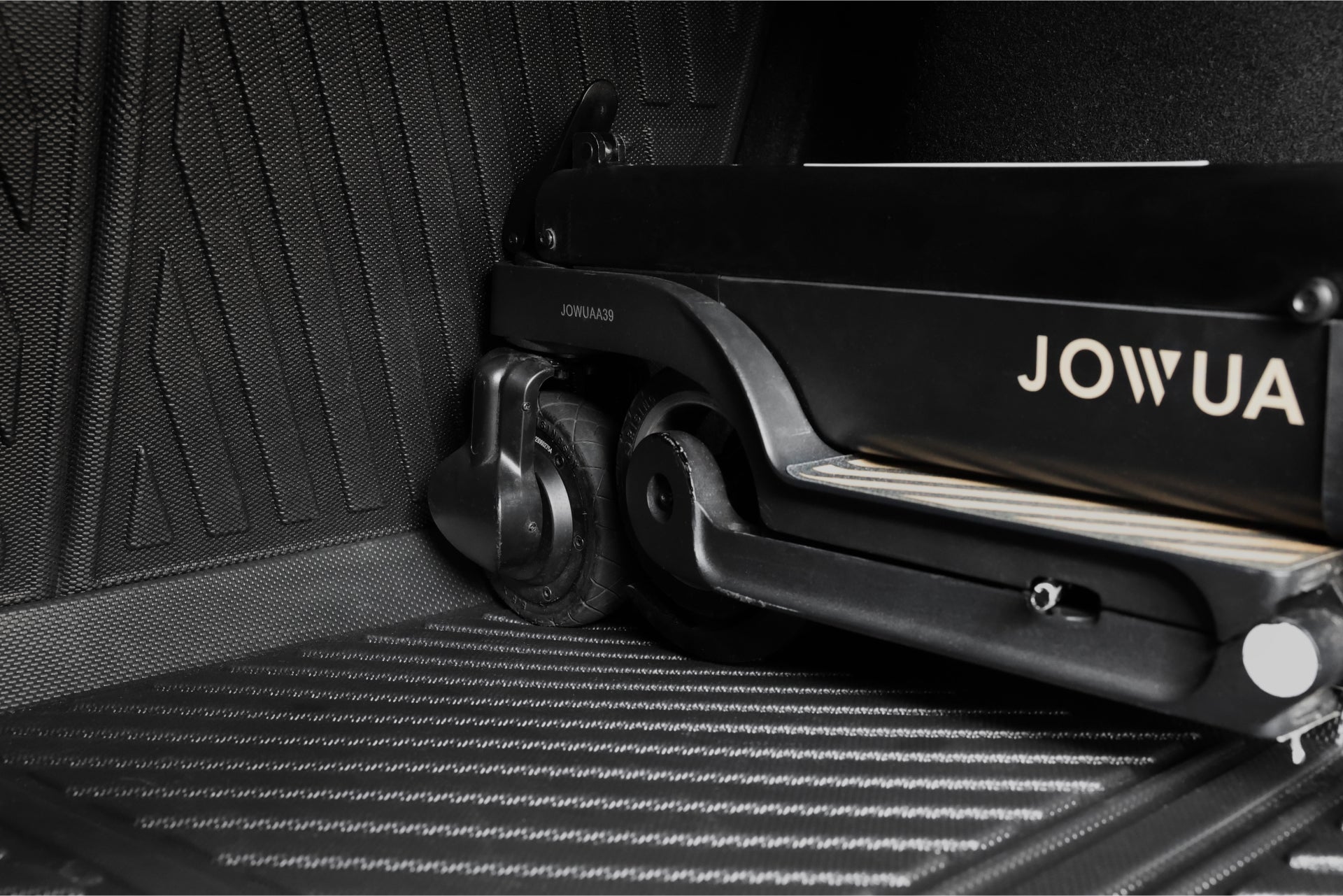 Close-up of a folded black electric scooter with the JOWUA logo, resting on the Model 3 All Weather Trunk Combo (Model 3 Highland, 2024+) textured liner.