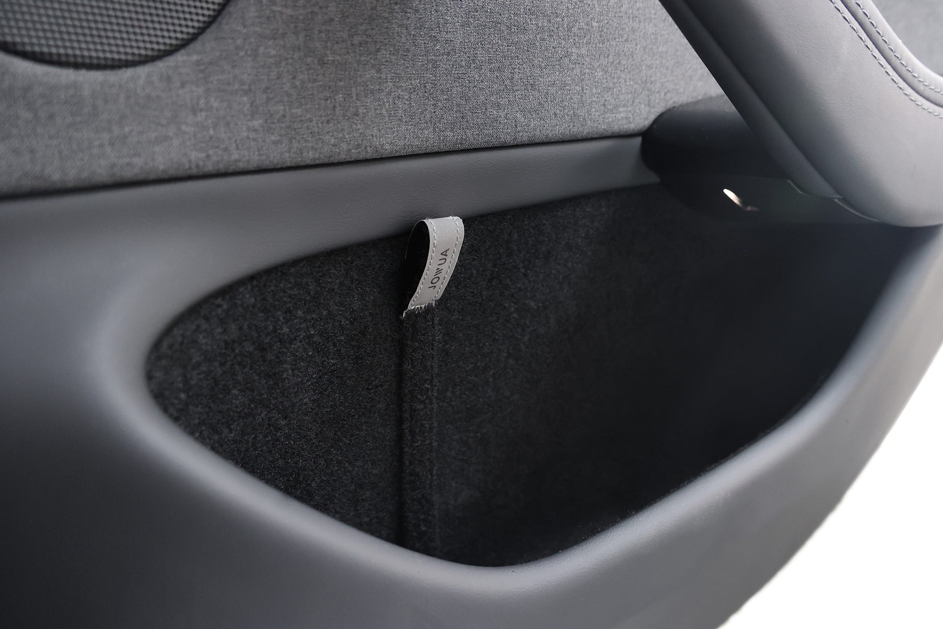 Close-up of a JOWUA Reflective Rear Door Emergency Release Strap for Model 3 Highland (2024+) and all Model Y, showing the black and gray door pocket, part of the handle, and safety-enhancing reflective strap.