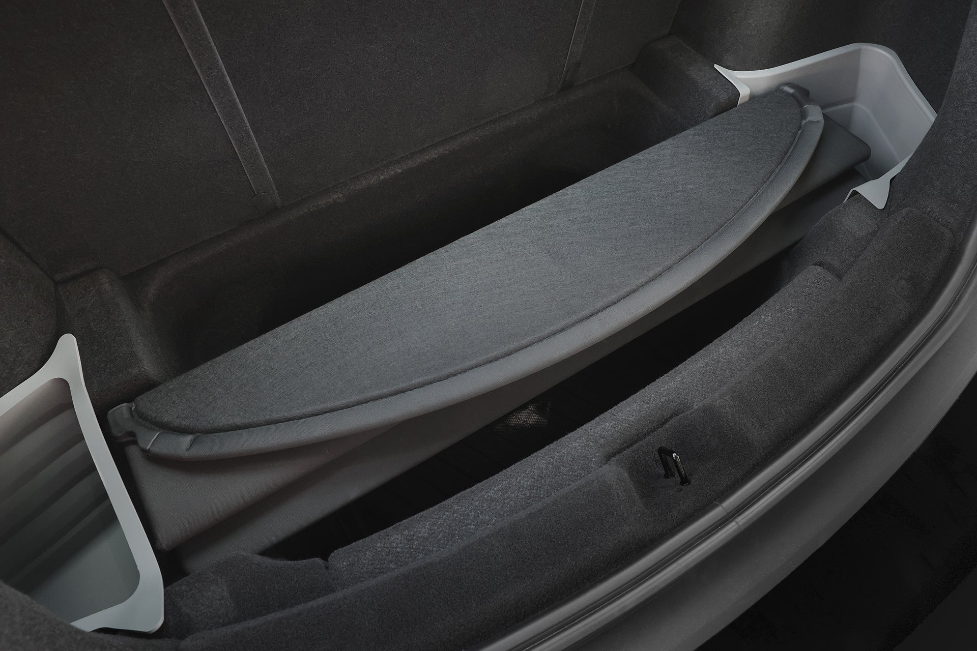 Close-up of a Tesla Model Y (2025+) trunk with dark upholstery, white side panels, and a hidden compartment—perfect for use with the JOWUA Model Y Juniper Trunk Combo for added protection and organization.