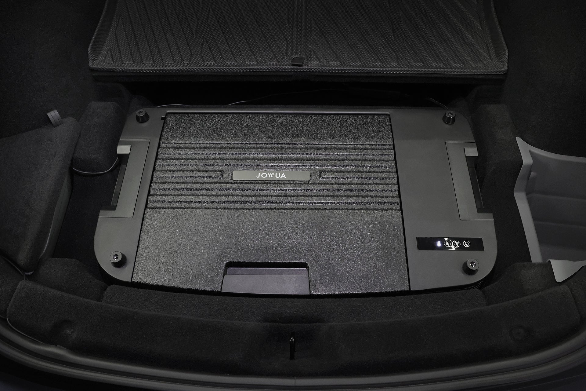 A close-up of the JOWUA Car Refrigerator for Tesla Model Y installed in the trunk, surrounded by dark lining and a rubber mat, featuring an intelligent dual-mode cooling system for optimal performance.