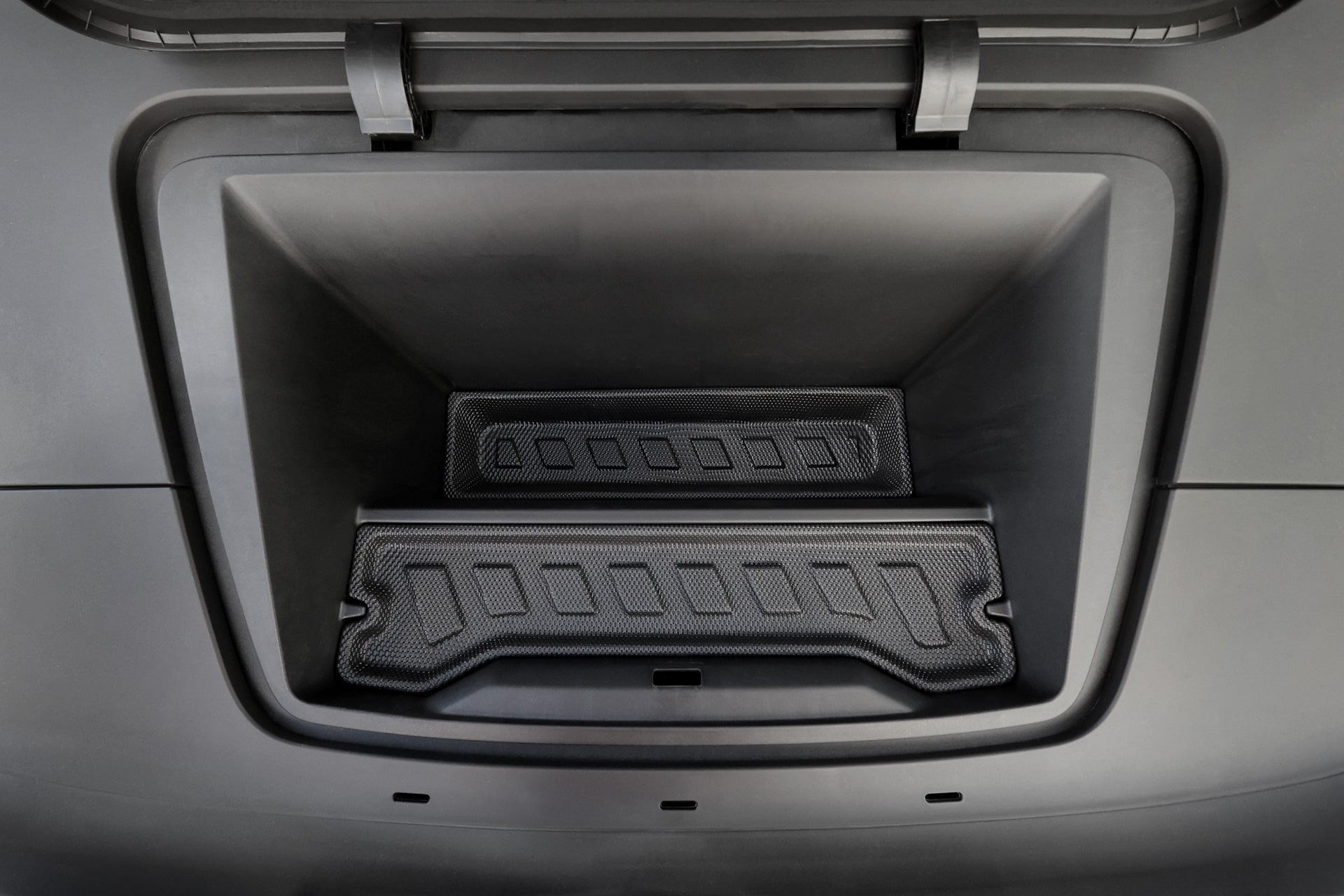 Close-up of an empty Volvo EX30 frunk with a clean, black interior featuring the JOWUA All Weather Trunk Liner + Rear Seat Cover, showcasing its durable molded design and striking geometric texture.