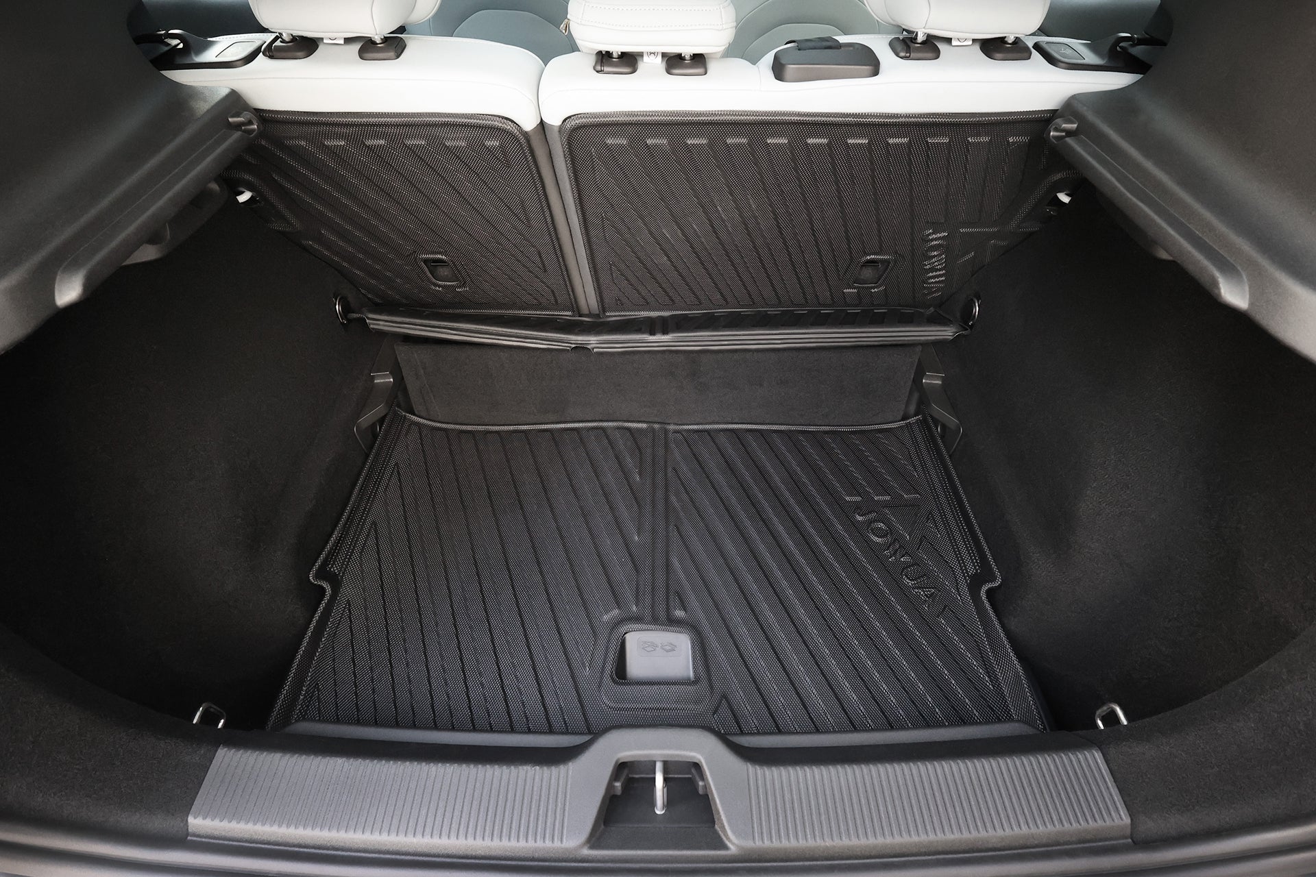 Open trunk of a Volvo EX30 with JOWUA All Weather Trunk Liner and Rear Seat Cover, viewed from behind. The custom-fit mat features a textured surface for protection, similar to an all-weather cargo liner.