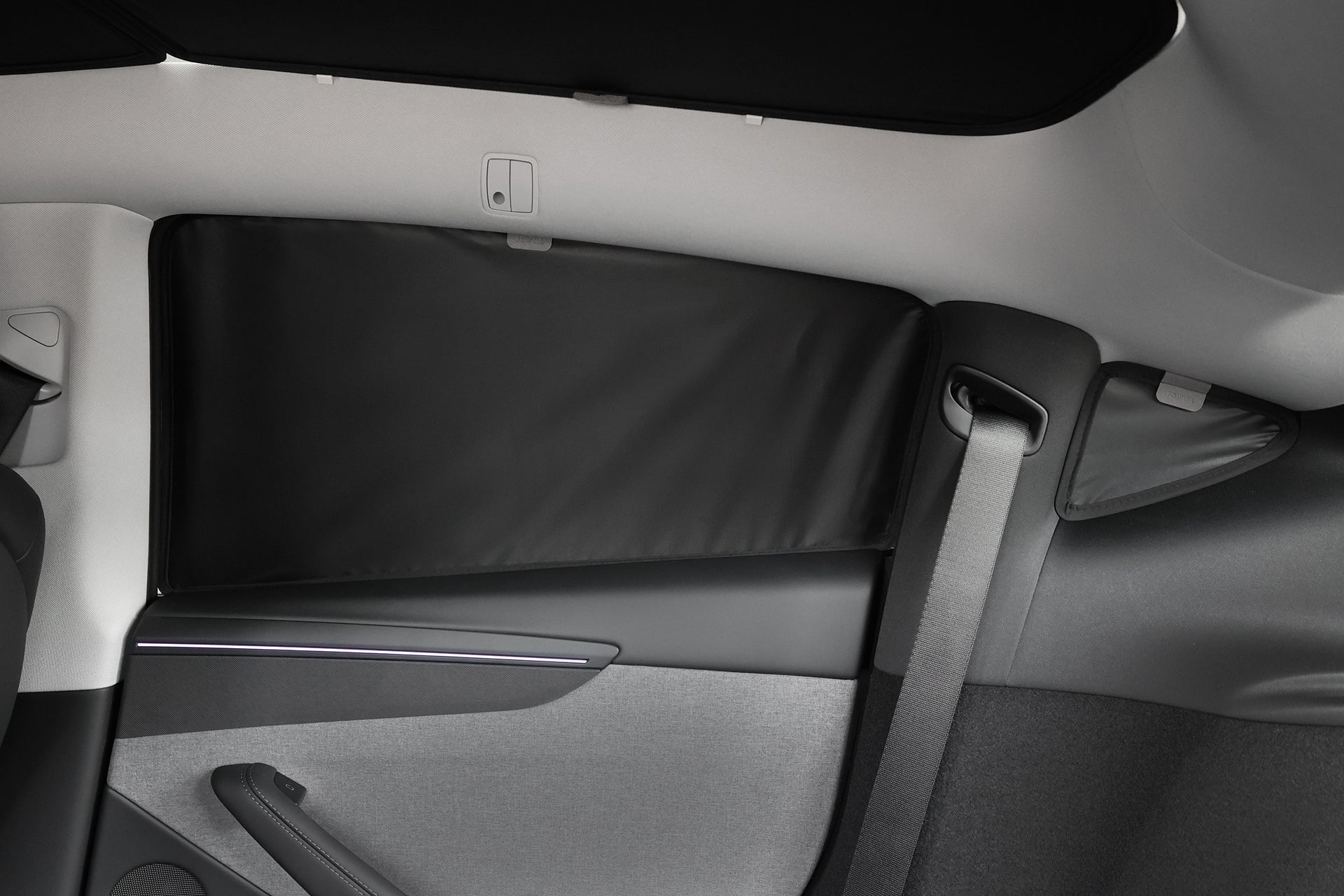 View of a car’s rear interior with the JOWUA Side + Rear Liftgate Window Sunshade for Model Y Juniper (2025+), custom-fit for the rear window to enhance privacy. Light gray upholstery, seatbelt, and parts of the rear seat and door are visible.