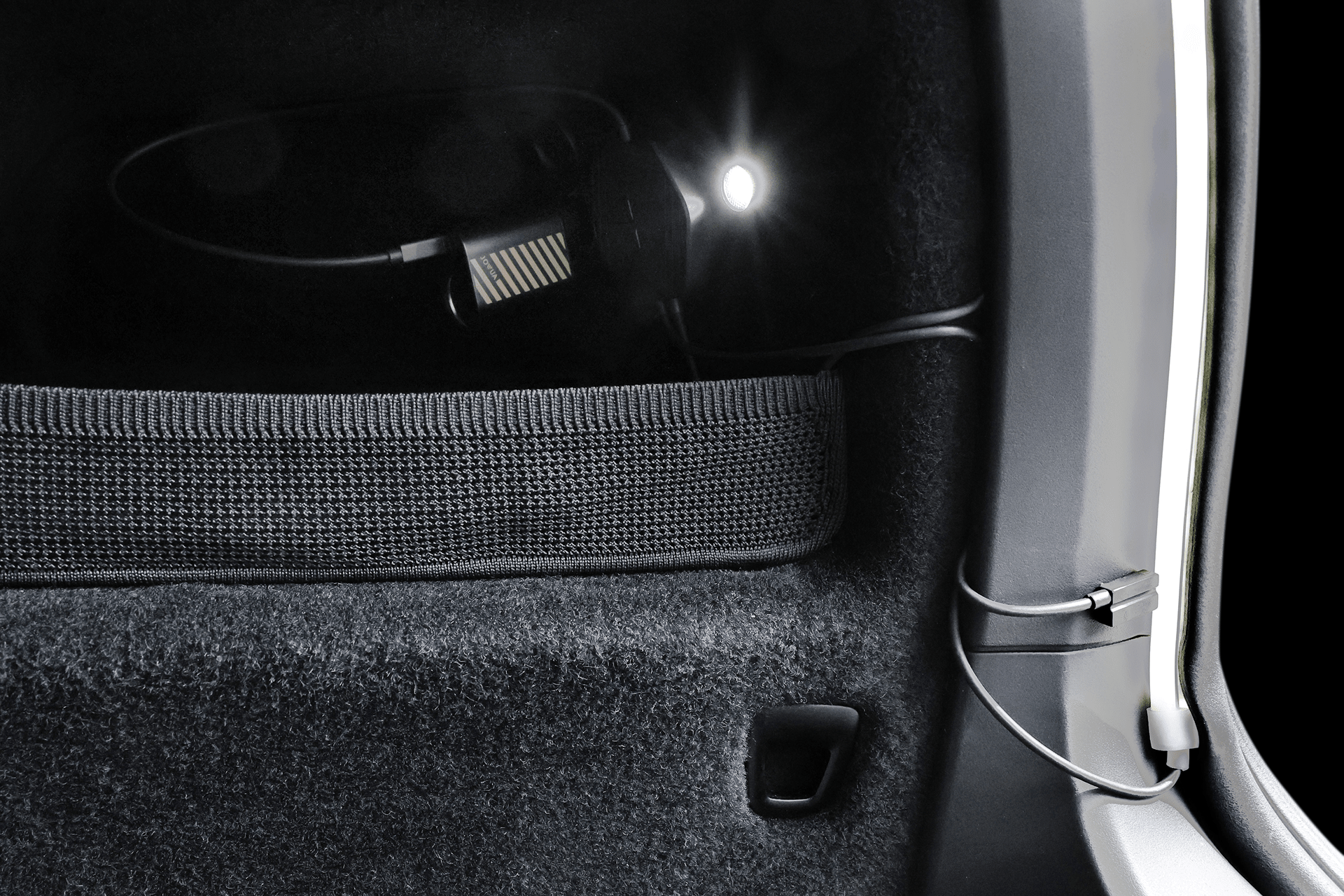 Close-up of a JOWUA Tesla Model X Trunk Ambient Light – USB-C LED Strip, installed above the mesh storage pocket. The black, textured trunk lining enhances its sleek look and functionality.