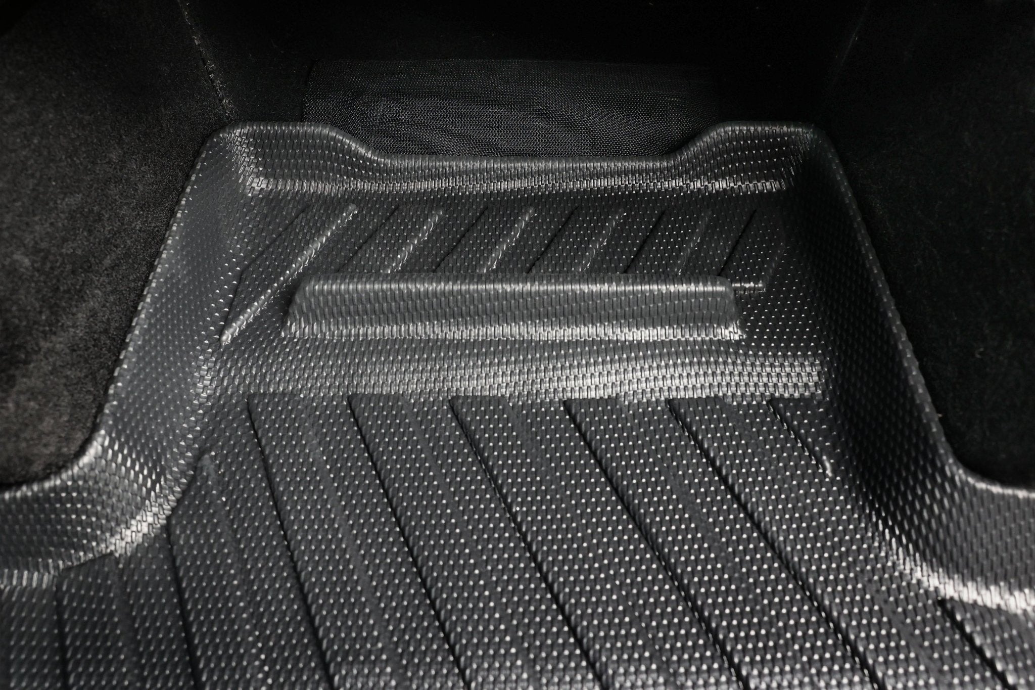 Close-up of JOWUA Model Y All-Weather Floor Liners Combo - Juniper Compatible (Right Hand Drive), featuring raised edges and diagonal grooves—an essential accessory for your Tesla Model Y interior protection.