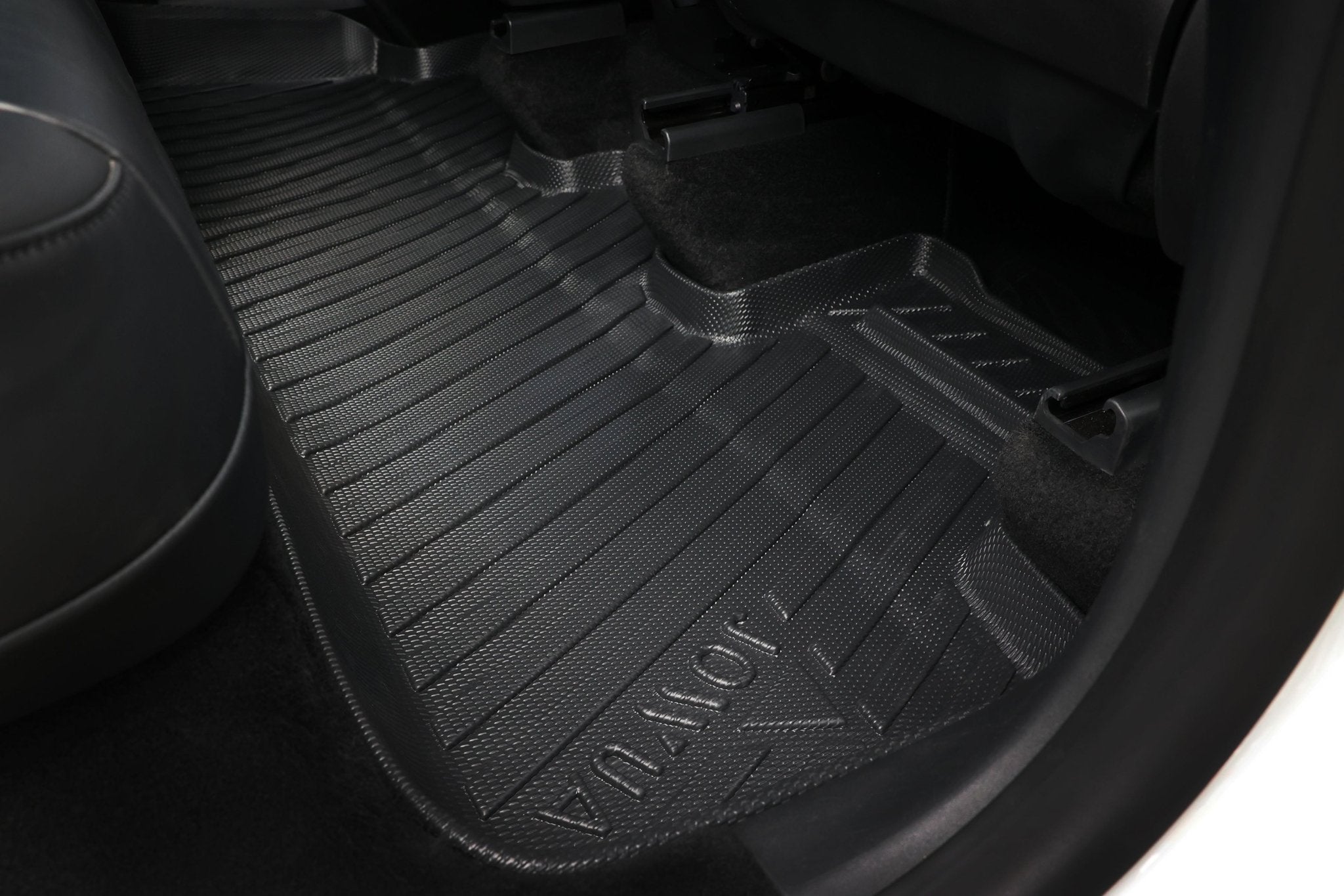 Close-up of a black, textured JOWUA Model Y (Juniper 2025+) All-Weather Floor Liner combo fitted in the rear, covering and protecting the carpet from dirt and spills with extended coverage beneath the seats.