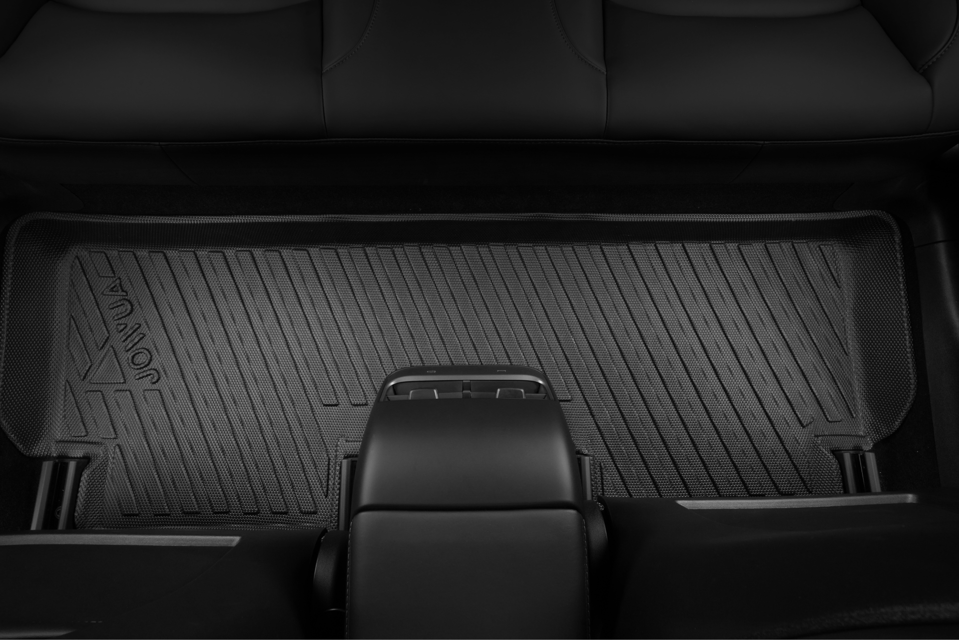 A close-up of the JOWUA Model 3 (2024+ Highland) All-Weather Floor Liners in black rubber covers the rear footwell, with the brand embossed in the corner. Black leather seats and center console are visible around the mat.