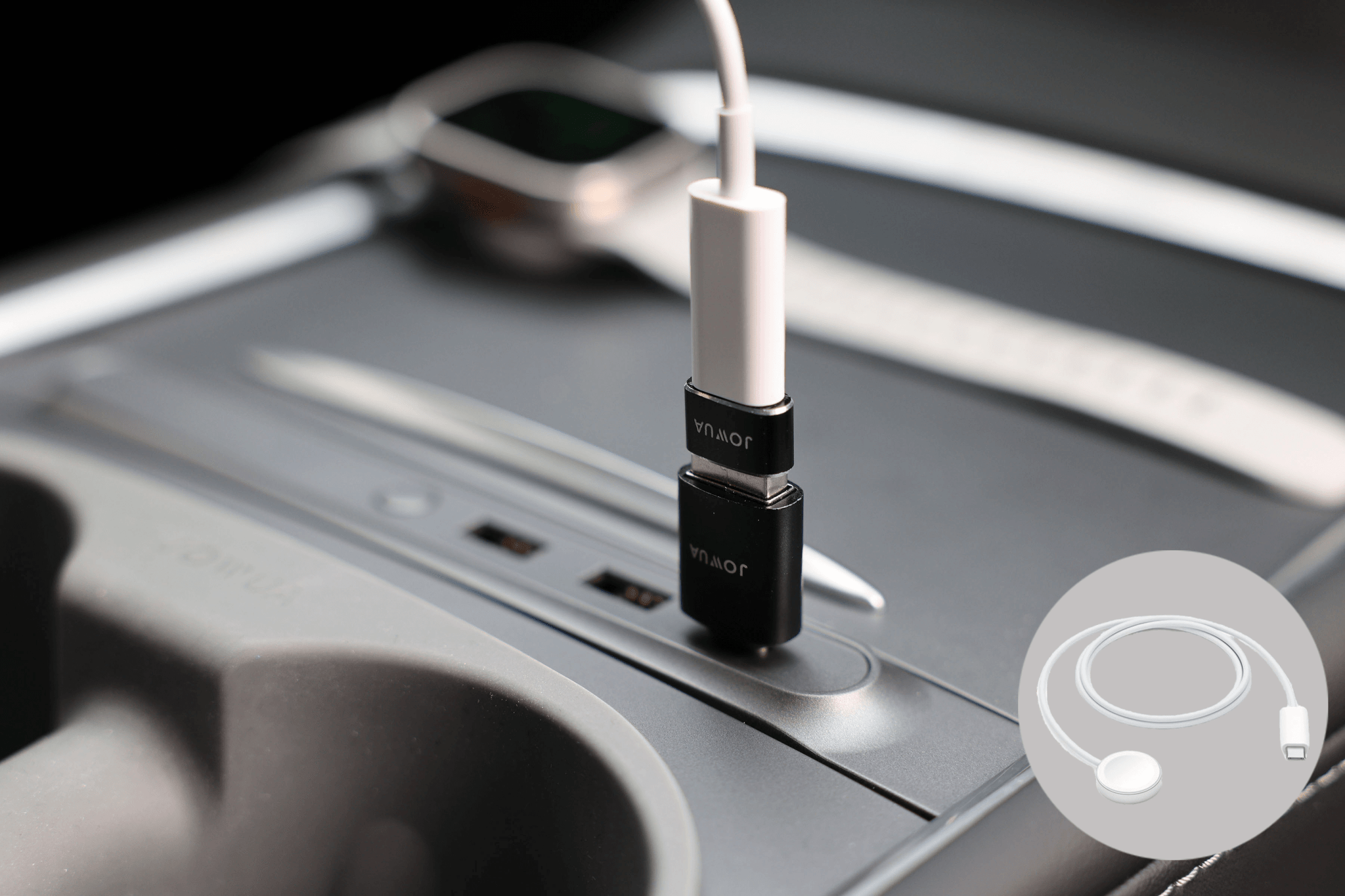 A close-up of a car’s center console displays the JOWUA Apple Watch Tesla Charging Kit in use, featuring a USB-C to USB-A adapter, a connected cable, and an Apple Watch with a white band. "Power Delivery" is illustrated in the lower right corner.