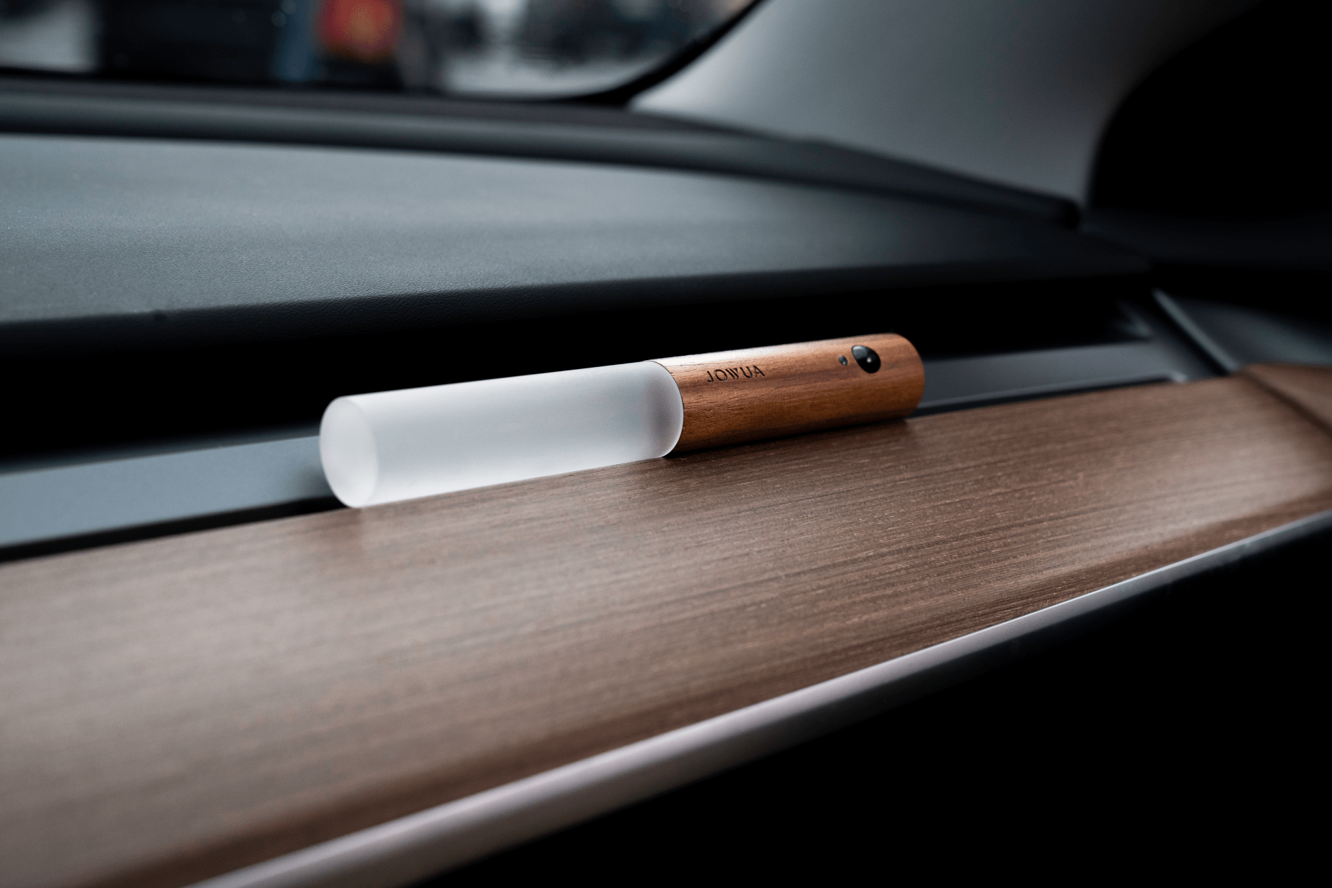 The JOWUA LED Light Bar for Tesla Center Console, featuring a sleek design with a wooden handle, frosted glass front, and rechargeable battery, sits elegantly on the car dashboard, perfectly complementing the Tesla's interior lighting and minimalist design.
