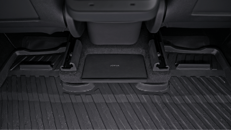 A close-up of the rear floor in a Tesla Model Y (Juniper 2025+) shows textured carpet, seat rails, and a JOWUA rectangular cover—perfectly matched with the JOWUA Model Y (Juniper 2025+) All-Weather Floor Liners Combo.