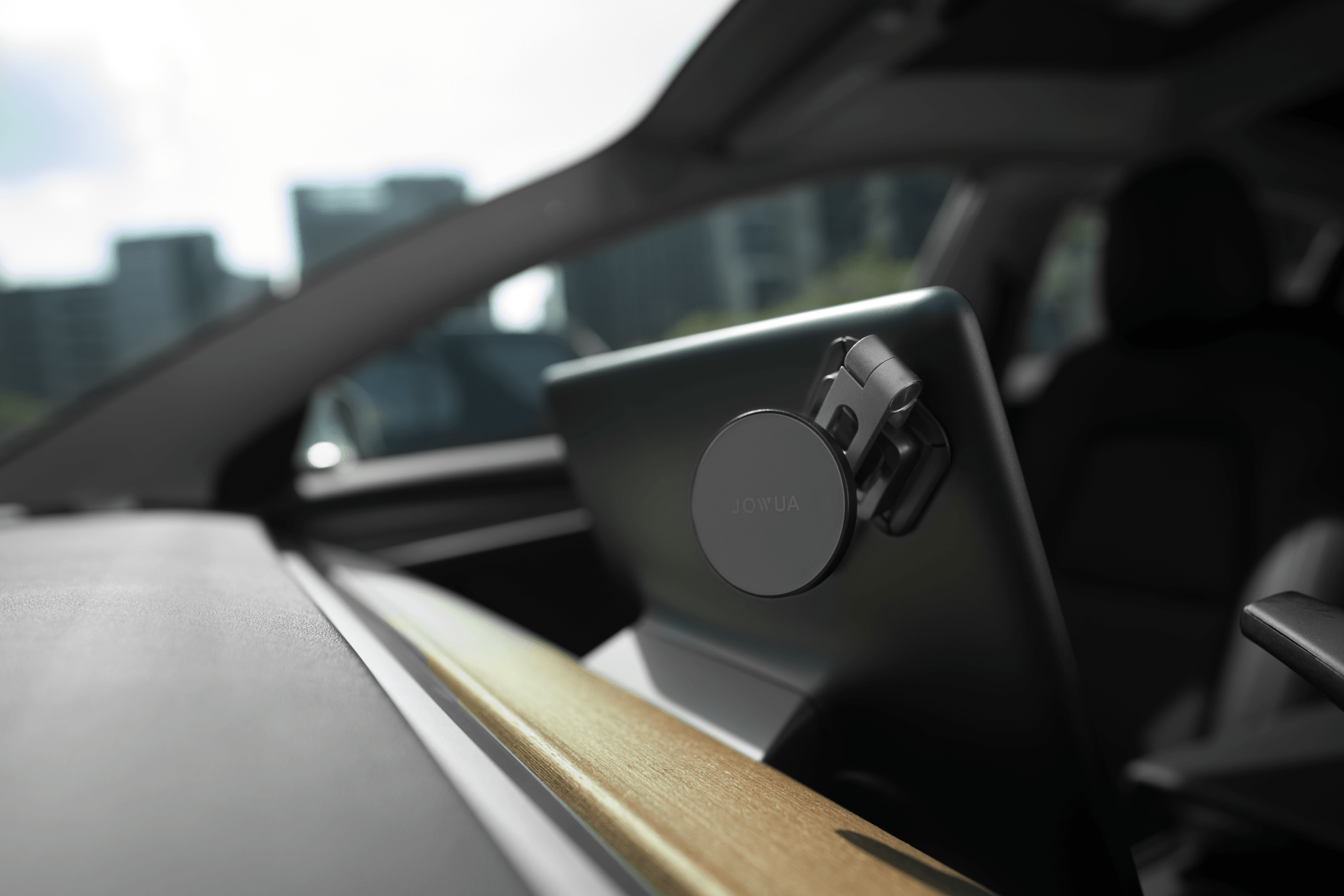 A smartphone mounted on a car's dashboard against a backdrop of modern city buildings, with sunlight streaming through the window, highlighting the sleek interior design.