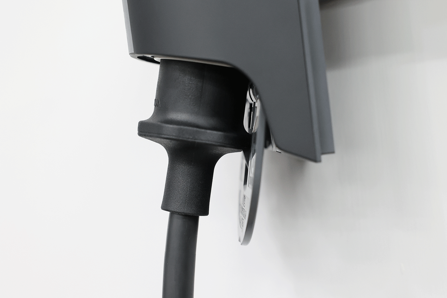 A black electric vehicle charging plug connected to a wall-mounted JOWUA JWDS-0033アダプター Tesla mobile connector adapter.