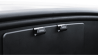 Close-up of a black car dashboard featuring two glovebox handles labeled "JOWUA Taiwan," with a discreet hook from the Hook Bundle (Model Y) for added convenience.