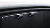 Close-up of two black glove compartment latches labeled "JOWUA" on a Model Y Juniper dashboard, part of the Premium Interior Essentials Set (RHD), highlighting minimalist, modern design and quality from JOWUA.