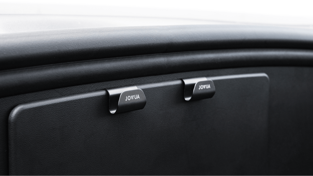 Close-up of a car's glove compartment featuring two handles labeled 