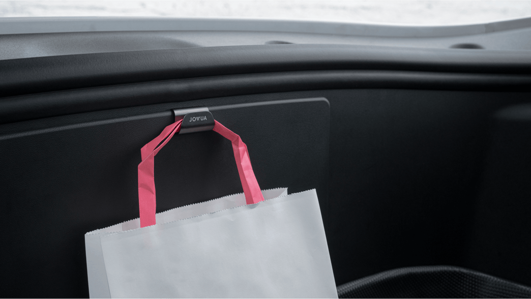 A JOWUA Front Trunk Hook holds a shopping bag labeled 