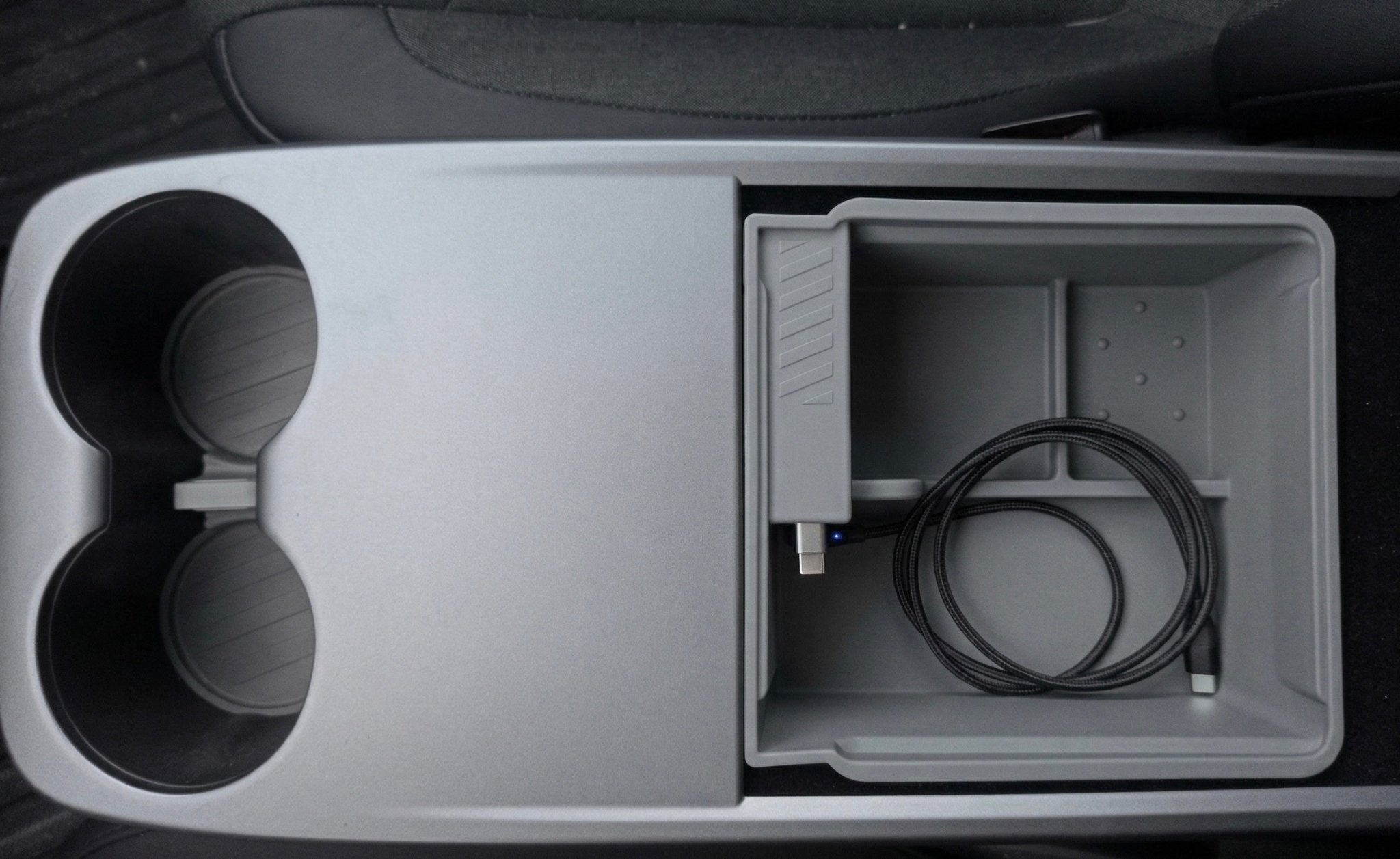 The JOWUA Armrest Storage Organizer Set with Power HUB for Tesla Model Y Standard 2026+ features two cup holders, an open compartment with a coiled black USB cable, and pairs perfectly with a silicone armrest mat or matching cup coaster set.