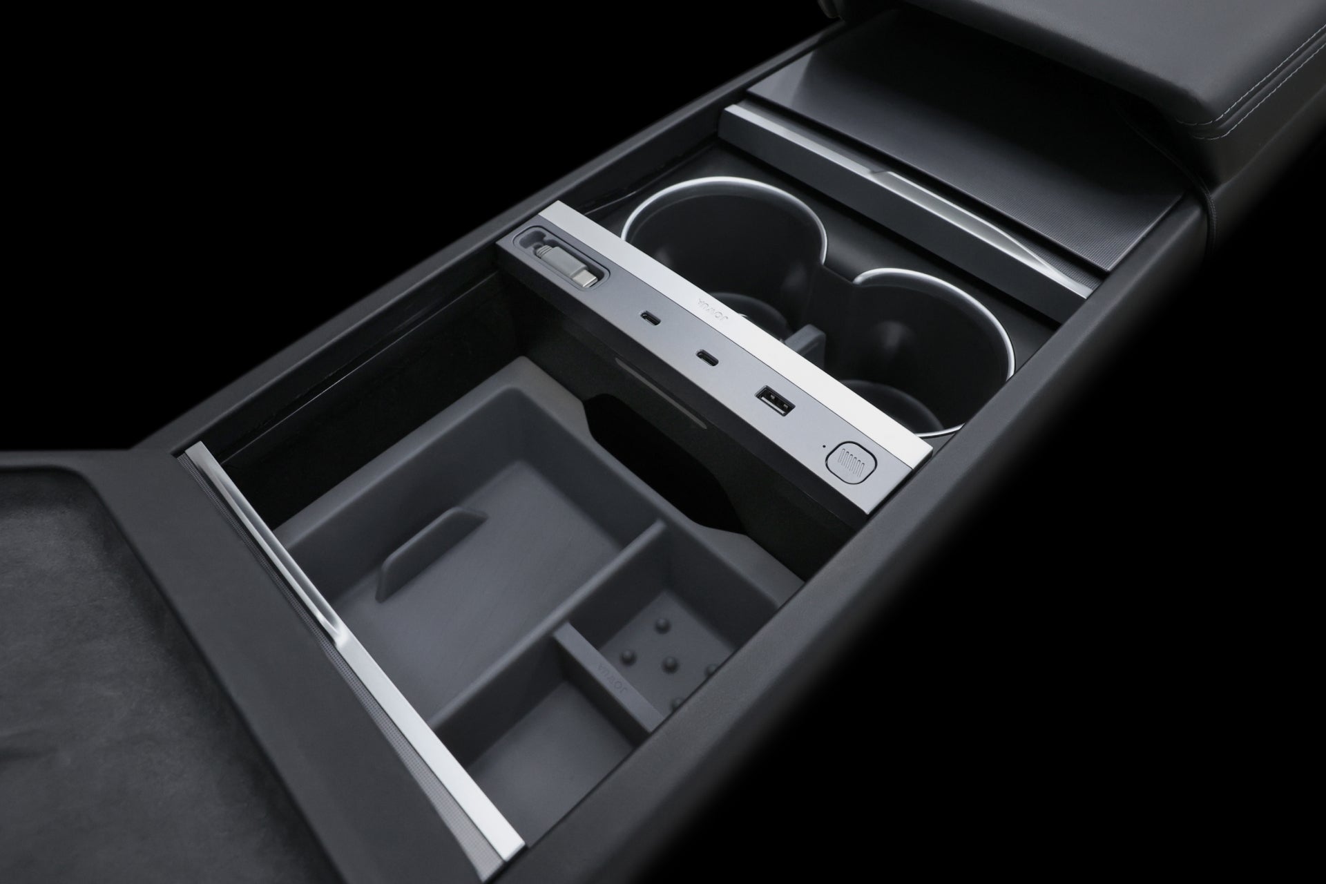 The JOWUA 130W LED Hub for Tesla Model Y Juniper 2025+ / Model 3 2024+ is a modern center console featuring sleek, dark materials, dynamic power management with multiple compartments, two cup holders, a USB port, and various buttons for an enhanced driving experience.