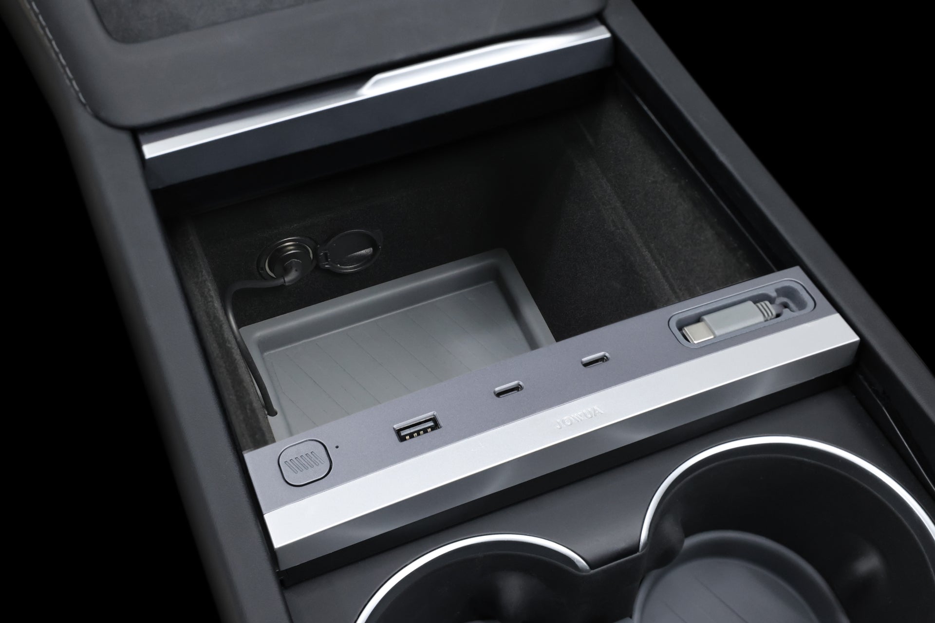 Explore the 130W LED Hub by JOWUA, a modern charging and storage solution for Tesla Model Y Juniper 2025+ / Model 3 2024+, with visible USB ports. It includes USB-A, USB-C, a 12V outlet, dynamic power management via slider, and two cup holders to enhance the vehicle's elegant interior.